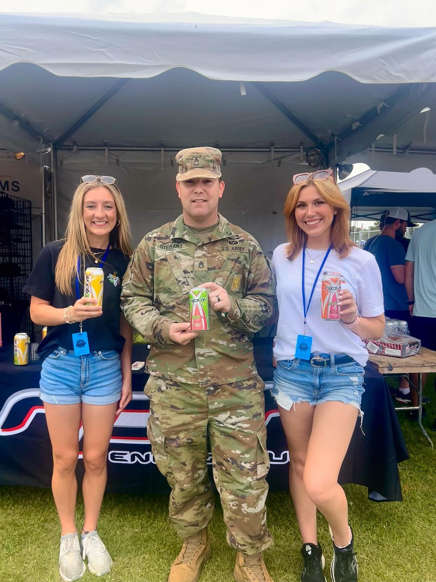 A soldier and two women holding energy drink cans at an outdoor booth.​​​​‌﻿‍﻿​‍​‍‌‍﻿﻿‌﻿​‍‌‍‍‌‌‍‌﻿‌‍‍‌‌‍﻿‍​‍​‍​﻿‍‍​‍​‍‌﻿​﻿‌‍​‌‌‍﻿‍‌‍‍‌‌﻿‌​‌﻿‍‌​‍﻿‍‌‍‍‌‌‍﻿﻿​‍​‍​‍﻿​​‍​‍‌‍‍​‌﻿​‍‌‍‌‌‌‍‌‍​‍​‍​﻿‍‍​‍​‍‌‍‍​‌﻿‌​‌﻿‌​‌﻿​​‌﻿​﻿​﻿‍‍​‍﻿﻿​‍﻿﻿‌﻿‌﻿‌﻿‌﻿‌﻿‌﻿​‍﻿‍‌﻿​‍‌‍‍‌‌﻿​​‌‍‍‌‌﻿‌​‌‍‌‌‌‍﻿‍‌‍‌‌‌﻿​‍‌‍‌﻿‌﻿‍‌​‍﻿‍‌‍​﻿‌‍﻿﻿‌‍﻿‌​‍﻿﻿‌‍‍‌‌‍﻿‍‌﻿‌​‌‍‌‌‌‍﻿‍‌﻿‌​​‍﻿﻿‌‍‌‌‌‍‌​‌‍‍‌‌﻿‌​​‍﻿﻿‌‍﻿‌‌‍﻿﻿‌‍‌​‌‍‌‌​﻿﻿‌‌﻿​​‌﻿​‍‌‍‌‌‌﻿​﻿‌‍‌‌‌‍﻿‍‌﻿‌​‌‍​‌‌﻿‌​‌‍‍‌‌‍﻿﻿‌‍﻿‍​﻿‍﻿‌‍‍‌‌‍‌​​﻿﻿‌‌‍​‌​﻿‌​​﻿​‍‌‍​‌​﻿‌﻿​﻿​​​﻿‍​​﻿‌‌​‍﻿‌​﻿​﻿​﻿‌‌​﻿​​​﻿​‍​‍﻿‌​﻿‌​​﻿​​​﻿‌​​﻿​‍​‍﻿‌‌‍​‌‌‍​‌‌‍‌‌‌‍‌‍​‍﻿‌​﻿​​​﻿​‌‌‍​‍‌‍‌‌​﻿​﻿​﻿‌​​﻿‍‌​﻿‌​‌‍​﻿​﻿‍​‌‍‌‍‌‍‌​​﻿‍﻿‌﻿‌​‌﻿‍‌‌﻿​​‌‍‌‌​﻿﻿‌‌‍﻿‌‌‍﻿﻿‌‍‌​‌﻿‌‌‌‍﻿​‌‍‌‌​﻿‍﻿‌﻿​​‌‍​‌‌﻿‌​‌‍‍​​﻿﻿‌‌‍​﻿‌‍​‌‌﻿​‍‌‍‌​‌‌​﻿‌‍​﻿‌﻿​‍‌‍﻿﻿‌‍﻿​‌‍﻿​​‍﻿‍‌‍​‍‌‍﻿﻿‌﻿‌​‌﻿‌​‌‍﻿﻿‌‍﻿‌‌‌﻿﻿‌﻿​﻿‌‍​﻿‌﻿​‍‌‍﻿﻿‌‍﻿​‌‍﻿​​‍‌‌​﻿‌‌‌​​‍‌‌﻿﻿‌‍‍﻿‌‍‌‌‌﻿‍‌​‍‌‌​﻿​﻿‌​‌​​‍‌‌​﻿​﻿‌​‌​​‍‌‌​﻿​‍​﻿​‍​﻿​​​﻿​‌​﻿‌​‌‍‌‌​﻿‍‌​﻿​﻿​﻿​﻿​﻿‌​​﻿​​​﻿‌‍​﻿‌﻿‌‍‌​​‍‌‌​﻿​‍​﻿​‍​‍‌‌​﻿‌‌‌​‌​​‍﻿‍‌‍‍‌‌‍﻿‌‌‍​‌‌‍‌﻿‌‍‌‌​‍﻿‍‌‍​‌‌‍﻿​‌﻿‌​​﻿﻿﻿‌‍​‍‌‍​‌‌﻿​﻿‌‍‌‌‌‌‌‌‌﻿​‍‌‍﻿​​﻿﻿‌‌‍‍​‌﻿‌​‌﻿‌​‌﻿​​‌﻿​﻿​‍‌‌​﻿​﻿‌​​‌​‍‌‌​﻿​‍‌​‌‍​‍‌‌​﻿​‍‌​‌‍‌﻿‌﻿‌﻿‌﻿‌﻿‌﻿​‍﻿‍‌﻿​‍‌‍‍‌‌﻿​​‌‍‍‌‌﻿‌​‌‍‌‌‌‍﻿‍‌‍‌‌‌﻿​‍‌‍‌﻿‌﻿‍‌​‍﻿‍‌‍​﻿‌‍﻿﻿‌‍﻿‌​‍‌‍‌‍‍‌‌‍‌​​﻿﻿‌‌‍​‌​﻿‌​​﻿​‍‌‍​‌​﻿‌﻿​﻿​​​﻿‍​​﻿‌‌​‍﻿‌​﻿​﻿​﻿‌‌​﻿​​​﻿​‍​‍﻿‌​﻿‌​​﻿​​​﻿‌​​﻿​‍​‍﻿‌‌‍​‌‌‍​‌‌‍‌‌‌‍‌‍​‍﻿‌​﻿​​​﻿​‌‌‍​‍‌‍‌‌​﻿​﻿​﻿‌​​﻿‍‌​﻿‌​‌‍​﻿​﻿‍​‌‍‌‍‌‍‌​​‍‌‍‌﻿‌​‌﻿‍‌‌﻿​​‌‍‌‌​﻿﻿‌‌‍﻿‌‌‍﻿﻿‌‍‌​‌﻿‌‌‌‍﻿​‌‍‌‌​‍‌‍‌﻿​​‌‍​‌‌﻿‌​‌‍‍​​﻿﻿‌‌‍​﻿‌‍​‌‌﻿​‍‌‍‌​‌‌​﻿‌‍​﻿‌﻿​‍‌‍﻿﻿‌‍﻿​‌‍﻿​​‍﻿‍‌‍​‍‌‍﻿﻿‌﻿‌​‌﻿‌​‌‍﻿﻿‌‍﻿‌‌‌﻿﻿‌﻿​﻿‌‍​﻿‌﻿​‍‌‍﻿﻿‌‍﻿​‌‍﻿​​‍‌‌​﻿‌‌‌​​‍‌‌﻿﻿‌‍‍﻿‌‍‌‌‌﻿‍‌​‍‌‌​﻿​﻿‌​‌​​‍‌‌​﻿​﻿‌​‌​​‍‌‌​﻿​‍​﻿​‍​﻿​​​﻿​‌​﻿‌​‌‍‌‌​﻿‍‌​﻿​﻿​﻿​﻿​﻿‌​​﻿​​​﻿‌‍​﻿‌﻿‌‍‌​​‍‌‌​﻿​‍​﻿​‍​‍‌‌​﻿‌‌‌​‌​​‍﻿‍‌‍‍‌‌‍﻿‌‌‍​‌‌‍‌﻿‌‍‌‌​‍﻿‍‌‍​‌‌‍﻿​‌﻿‌​​‍​‍‌﻿﻿‌