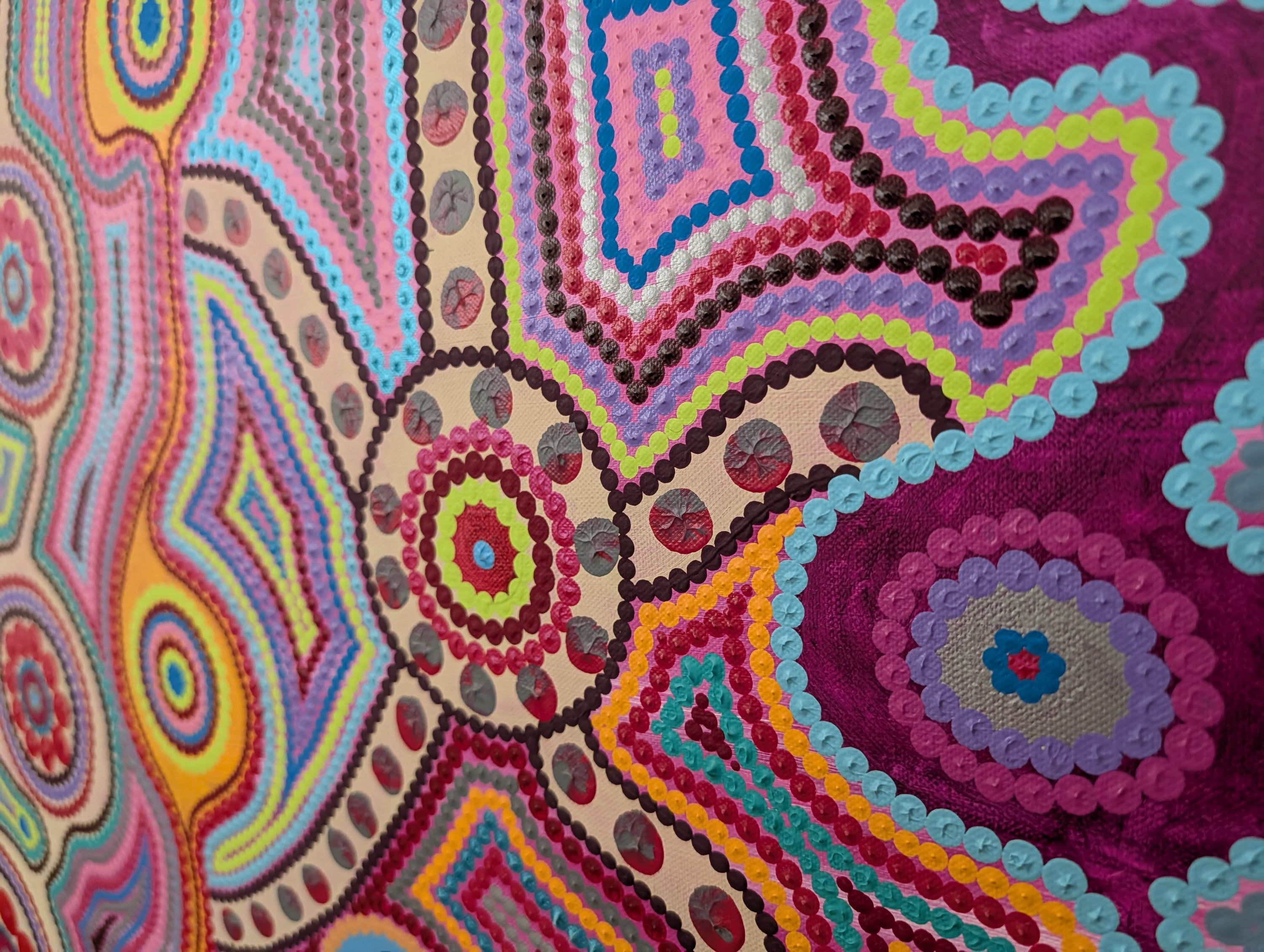 Détail saisissant de Caroline Pons: art aborigène contemporain. Motifs de points vibrants aux couleurs rose, bleu, vert, magenta et textures riches sur toile.