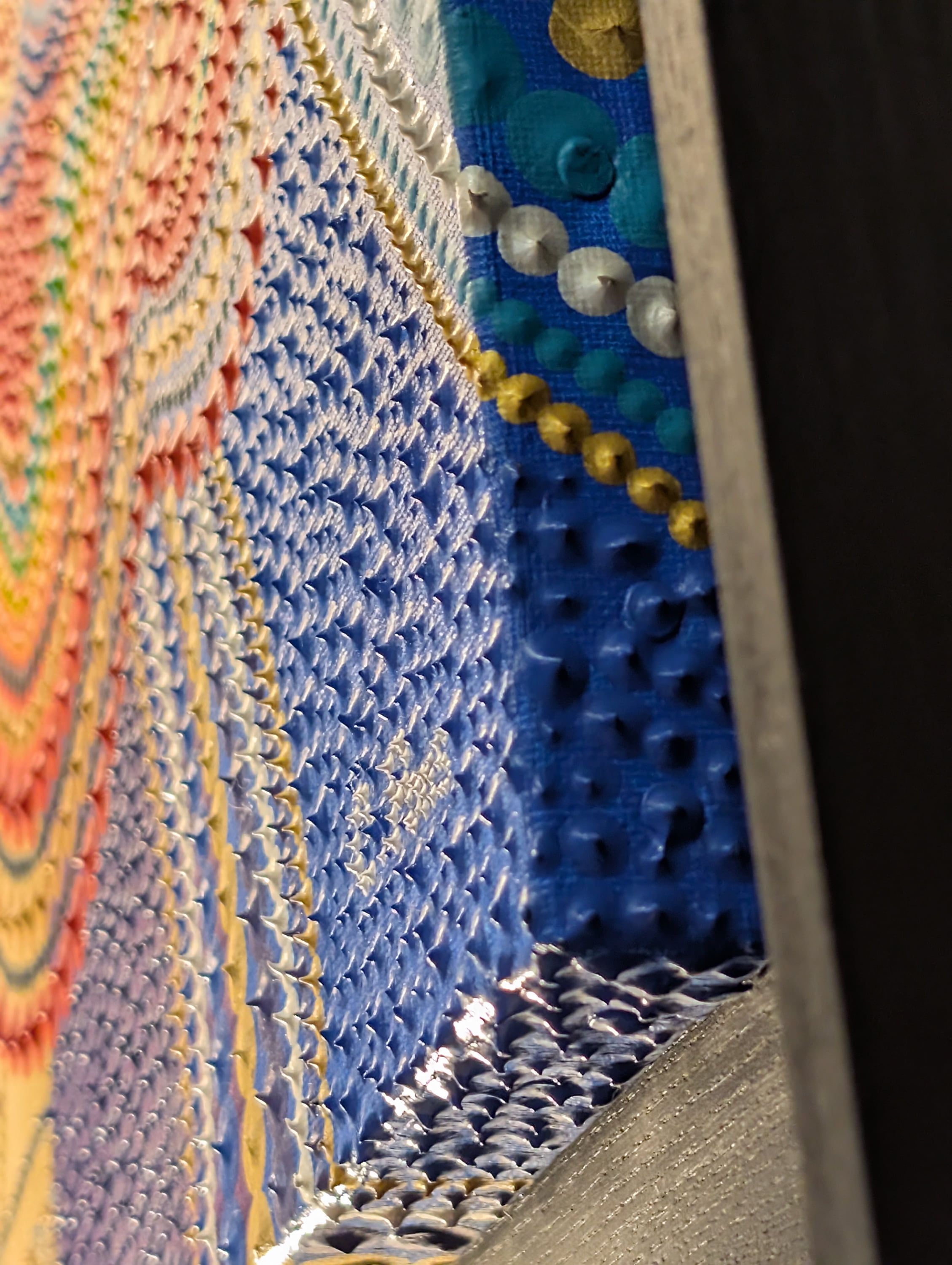 Gros plan texturé de l'œuvre "Libération" de Caroline Pons. Points et motifs en relief, couleurs vibrantes arc-en-ciel et bleu-or, un magnifique tableau abstrait contemporain.