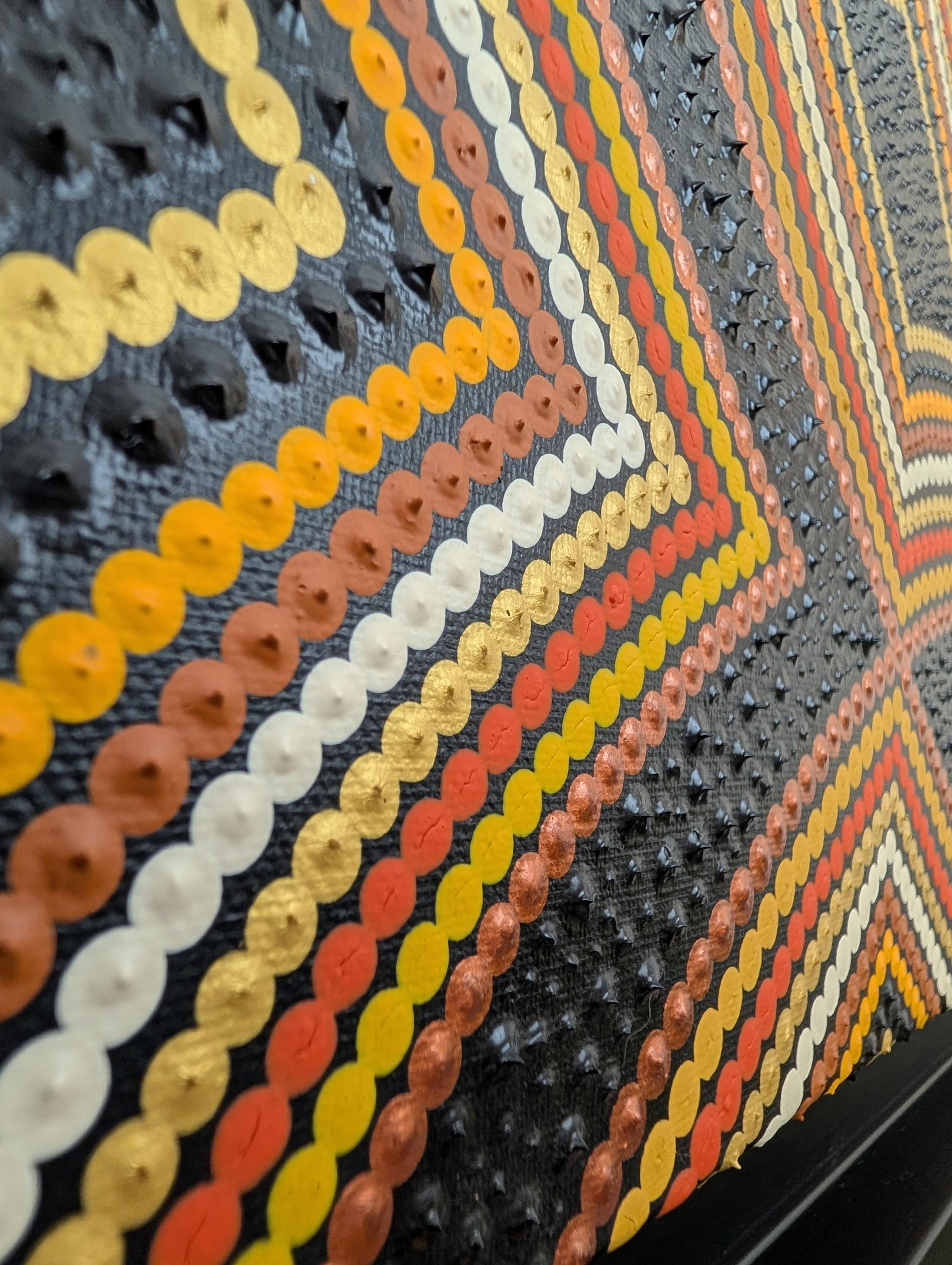 Détail de 'La Danse des Formes' par Caroline Pons, révélant la texture d'un Art aborigène contemporain. Rangées de points or, orange, blanc et bruns sur fond noir texturé.