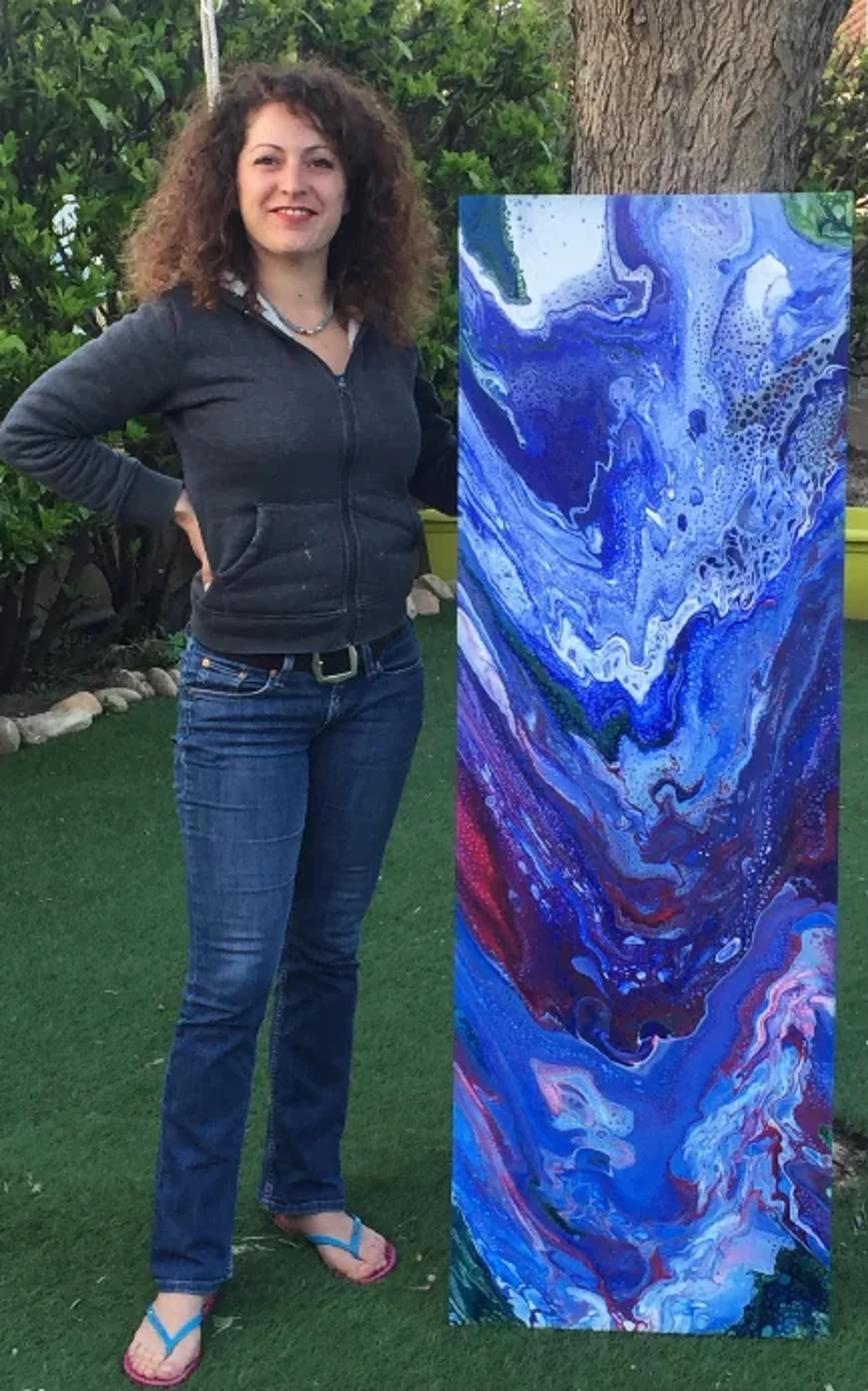 Caroline Pons présente son tableau abstrait contemporain "Cascade", une œuvre fluide aux bleus intenses, turquoises, blancs, avec des tourbillons et touches de magenta, devant la nature.