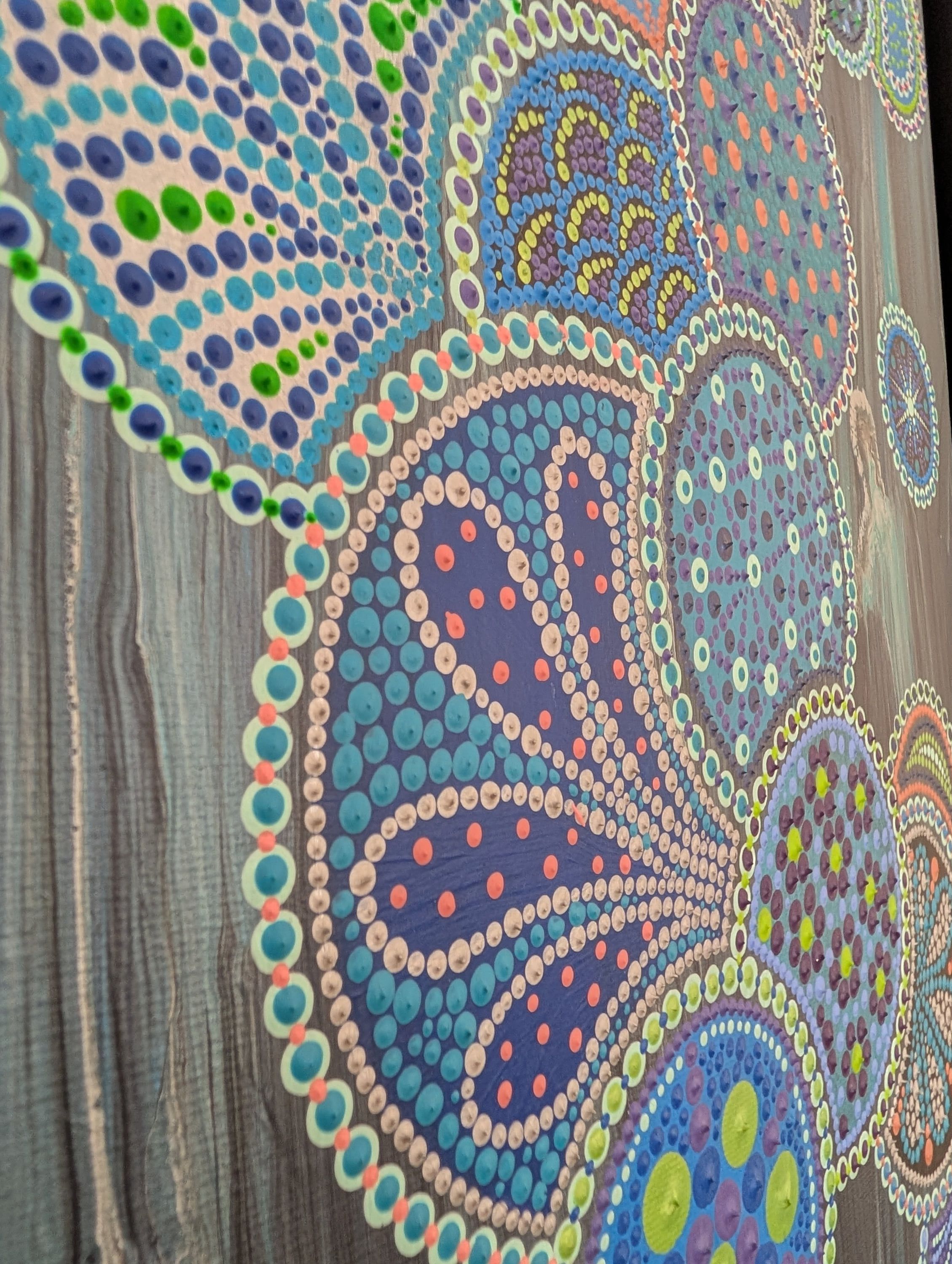 Gros plan d'Eclosion céleste 3 de Caroline Pons, un tableau abstrait contemporain. Détail de points colorés bleus, verts, violets, orangés formant des motifs circulaires sur fond texturé gris-bleu.