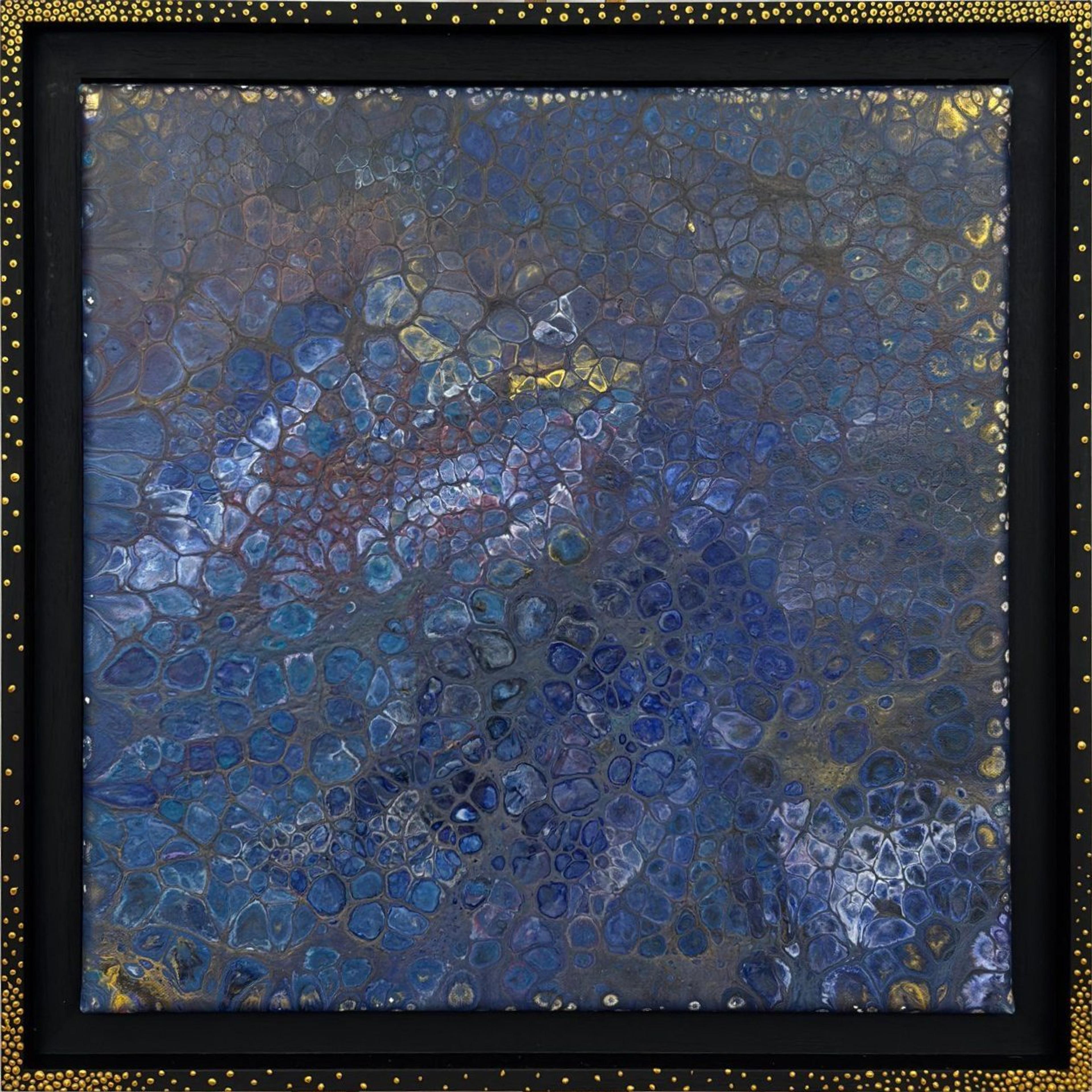 "Rêve indigo" by Caroline Pons, a modern abstract painting with blue, indigo & gold cells. Black American box frame with gold dots on a wooden easel.