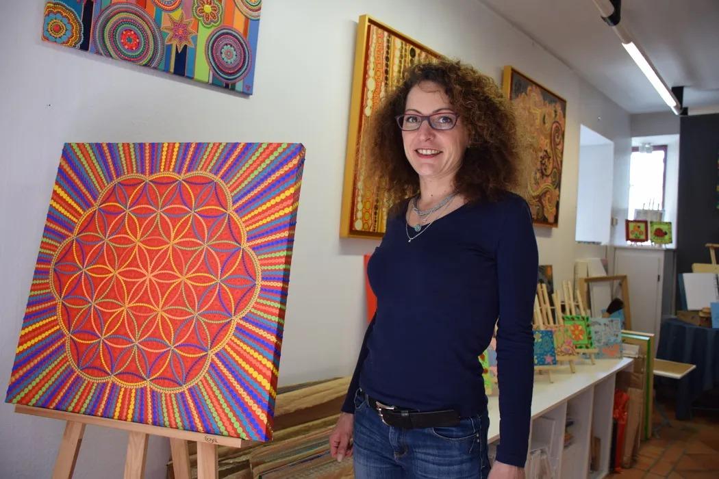 Caroline Pons dans son atelier-galerie, rue Marchande, près d'une toile en fleur de vie