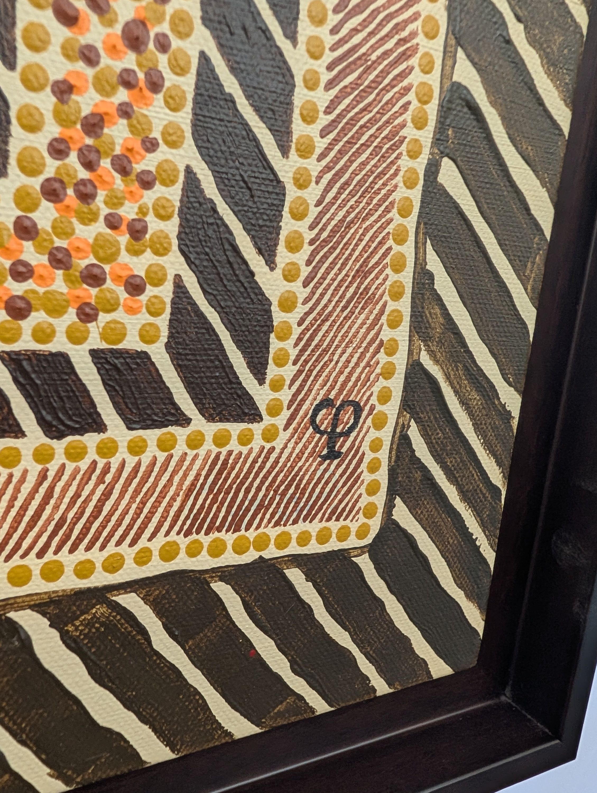 Détail encadré de l'œuvre Les Tortues de Caroline Pons, mettant en lumière le pointillisme. Points jaunes, orange et marron, motifs rayés sombres, typiques de l'Art aborigène contemporain.