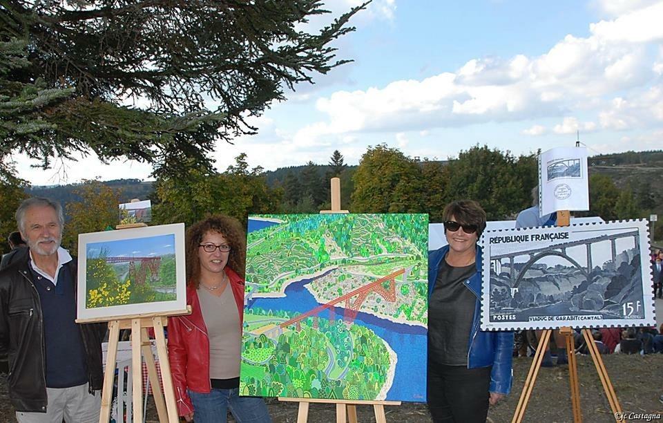 Caroline Pons beside her painting of the Garabit viaduct, between two other painters of the competition