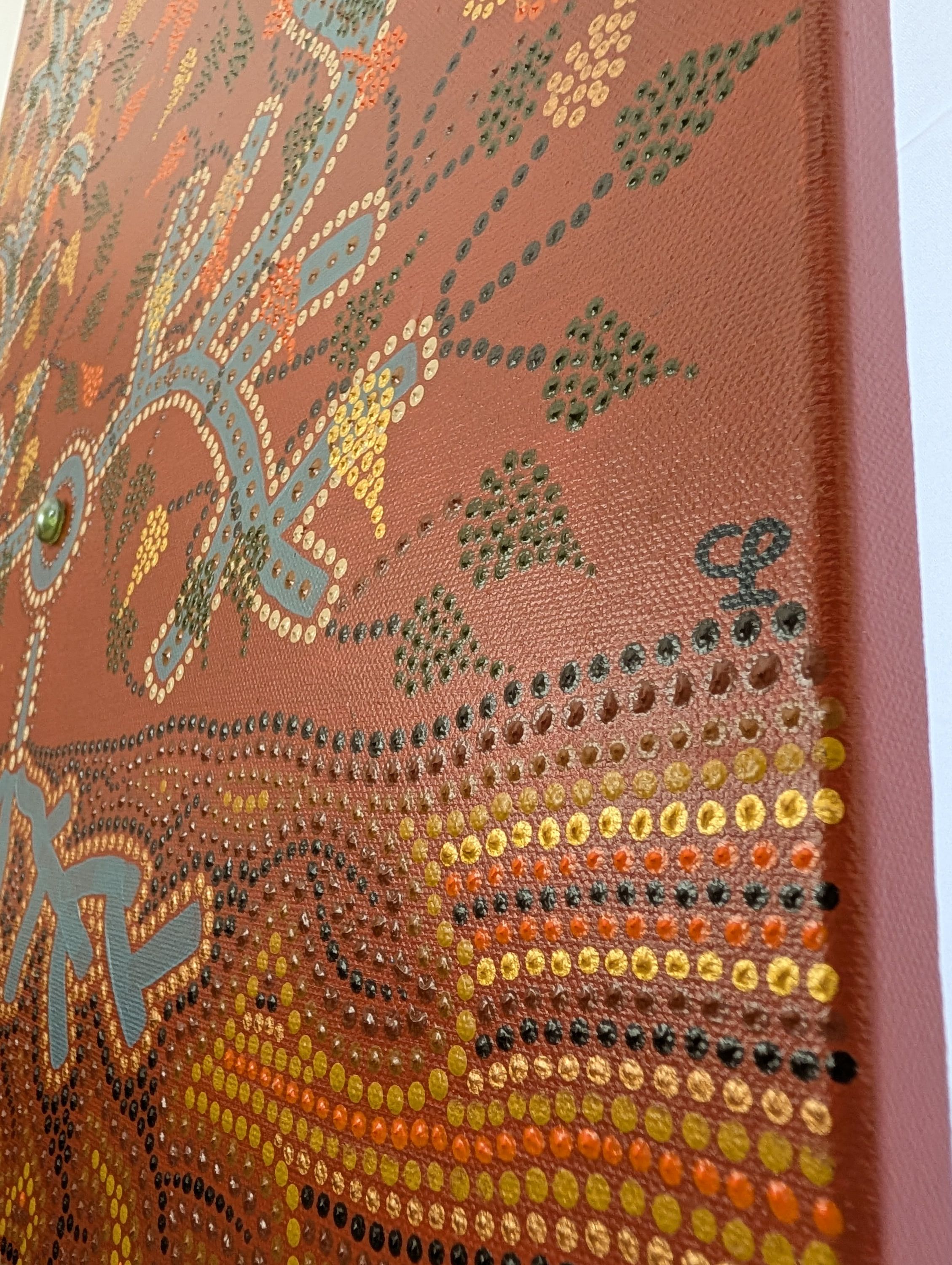 Close-up of Caroline Pons's 'L'arbre' artwork, detail 1, showcasing contemporary aboriginal-style art. Raised blue, yellow, green, gold dots on terracotta background, vibrant texture.