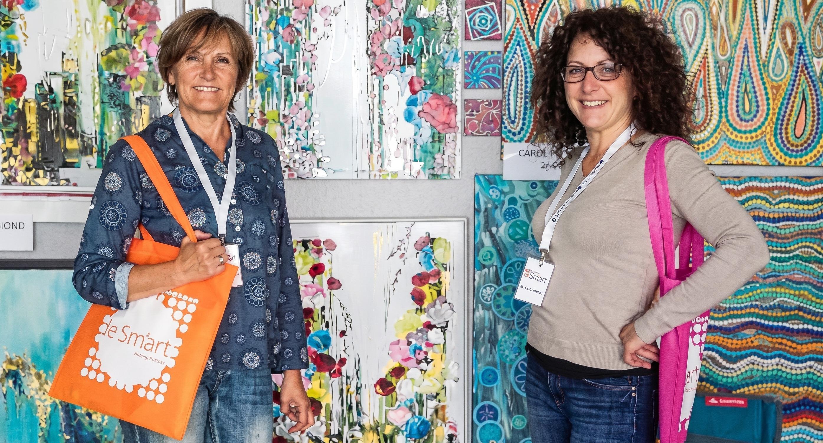 Caroline Pons (right) at the Sm'Art fair in Aix-en-Provence, in front of her dot paintings