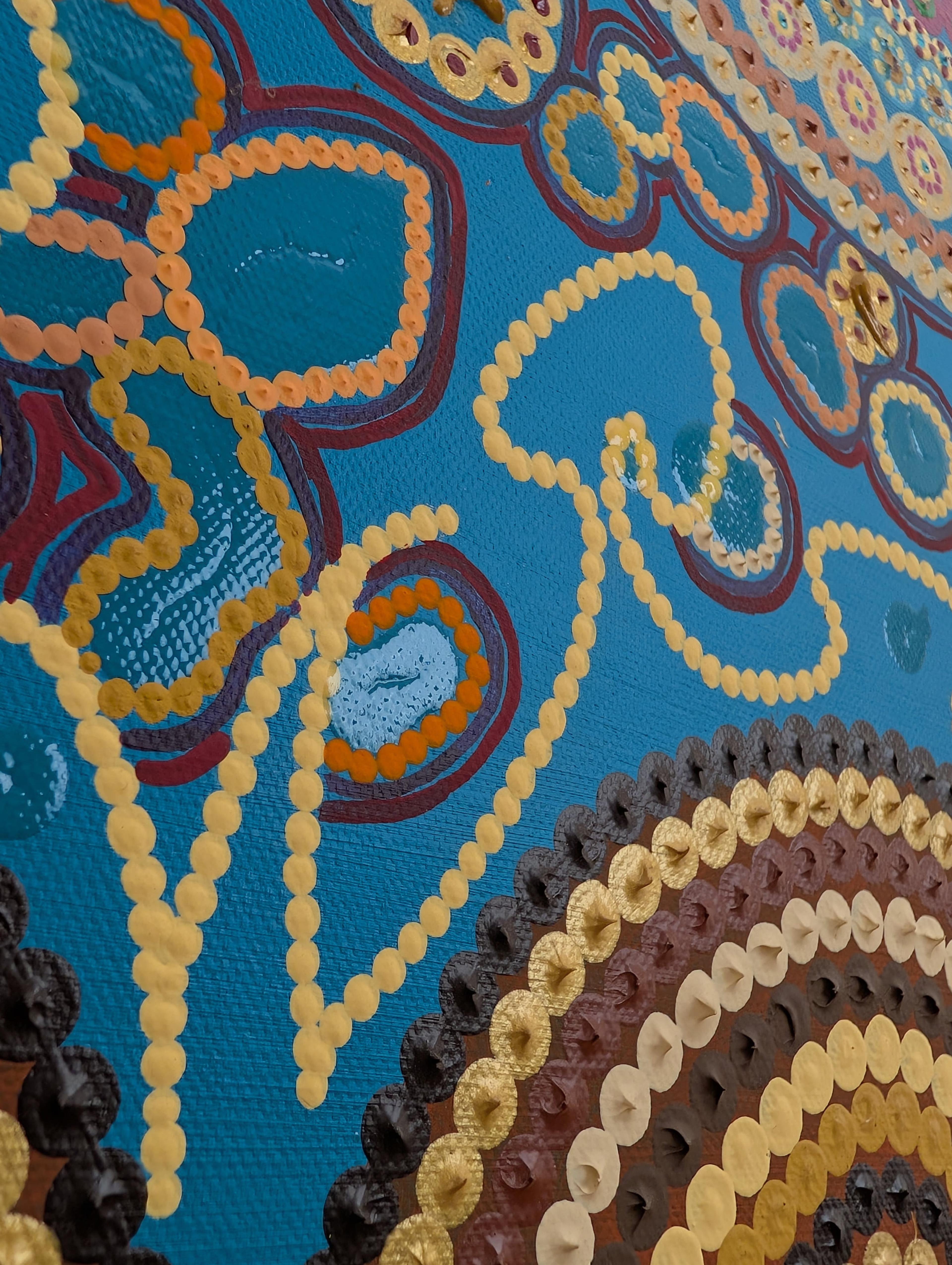 Detail of Caroline Pons' "Where do I live". This contemporary aboriginal-style art features vibrant gold, orange, and brown dot patterns on a textured teal canvas.
