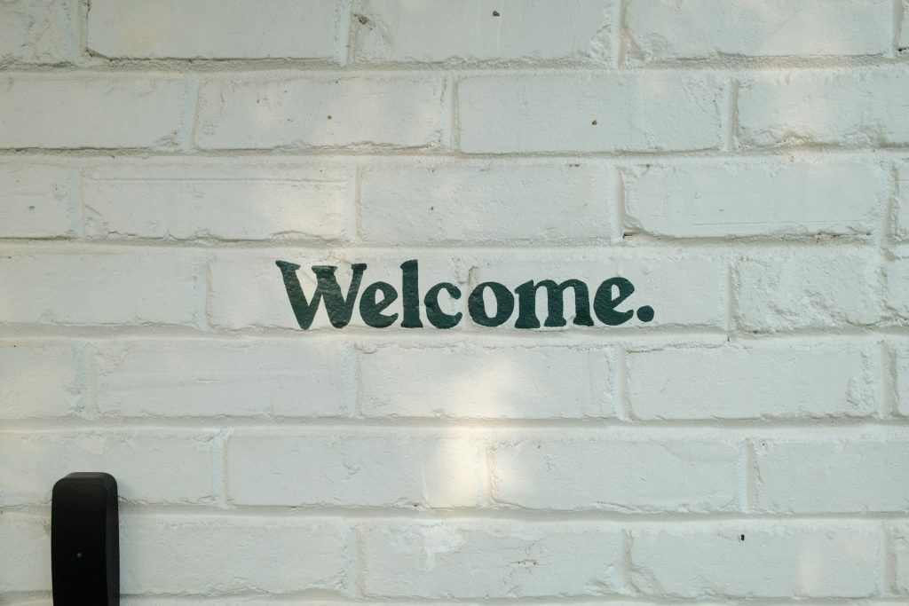 The word 'Welcome.' painted on a white brick wall