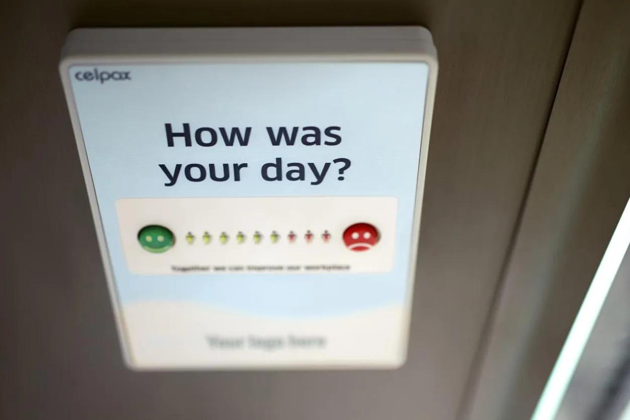 A feedback kiosk reading "How was your day?" with a row of emoji rating buttons from happy to sad