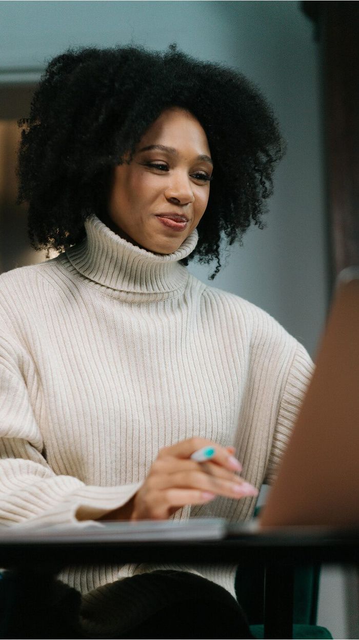 Woman smiling while working on a laptop