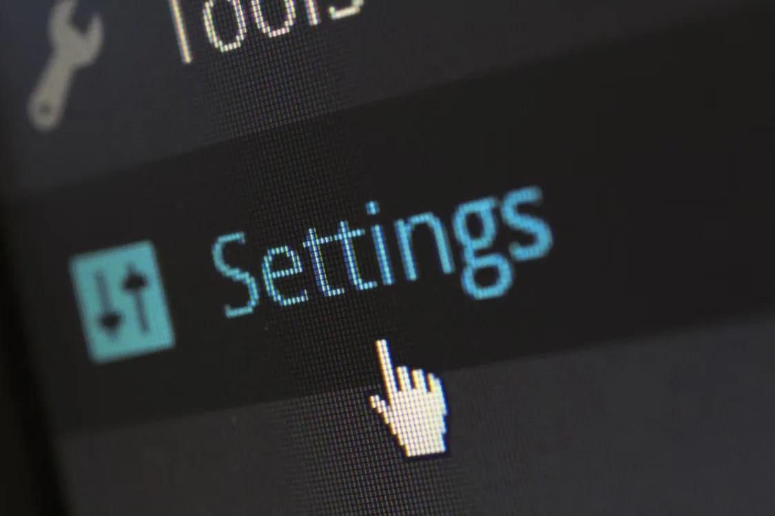 Close-up of a phone screen showing a cursor tapping a "Settings" menu option