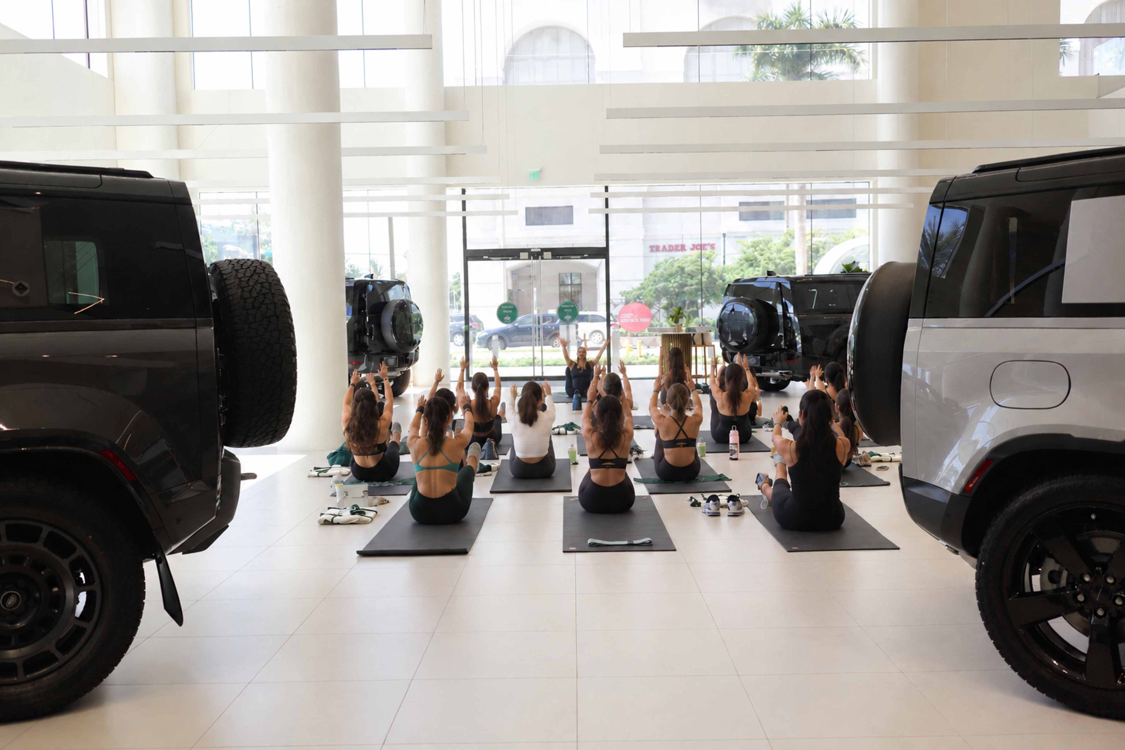 Pilates class set up inside Land Rover Coral Gables showroom with Range Rover Sport in the background