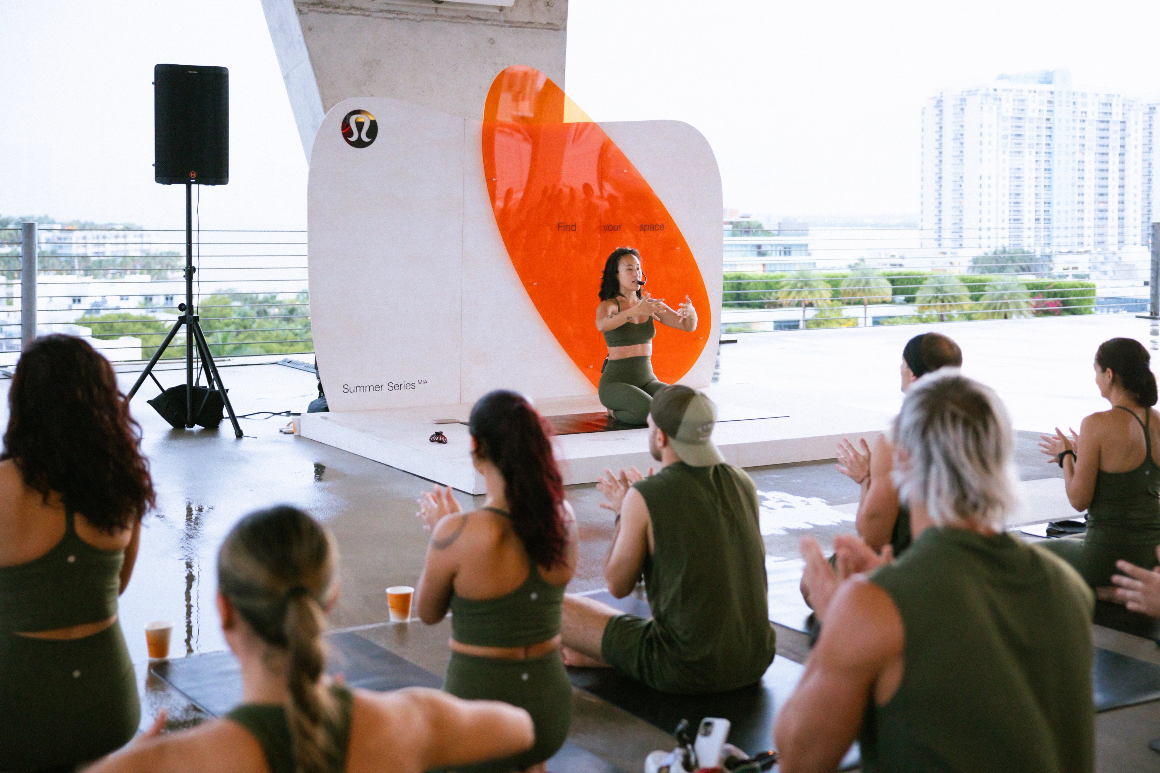 Participants face a white-and-orange lululemon backdrop during a session at 1111 Lincoln Road.