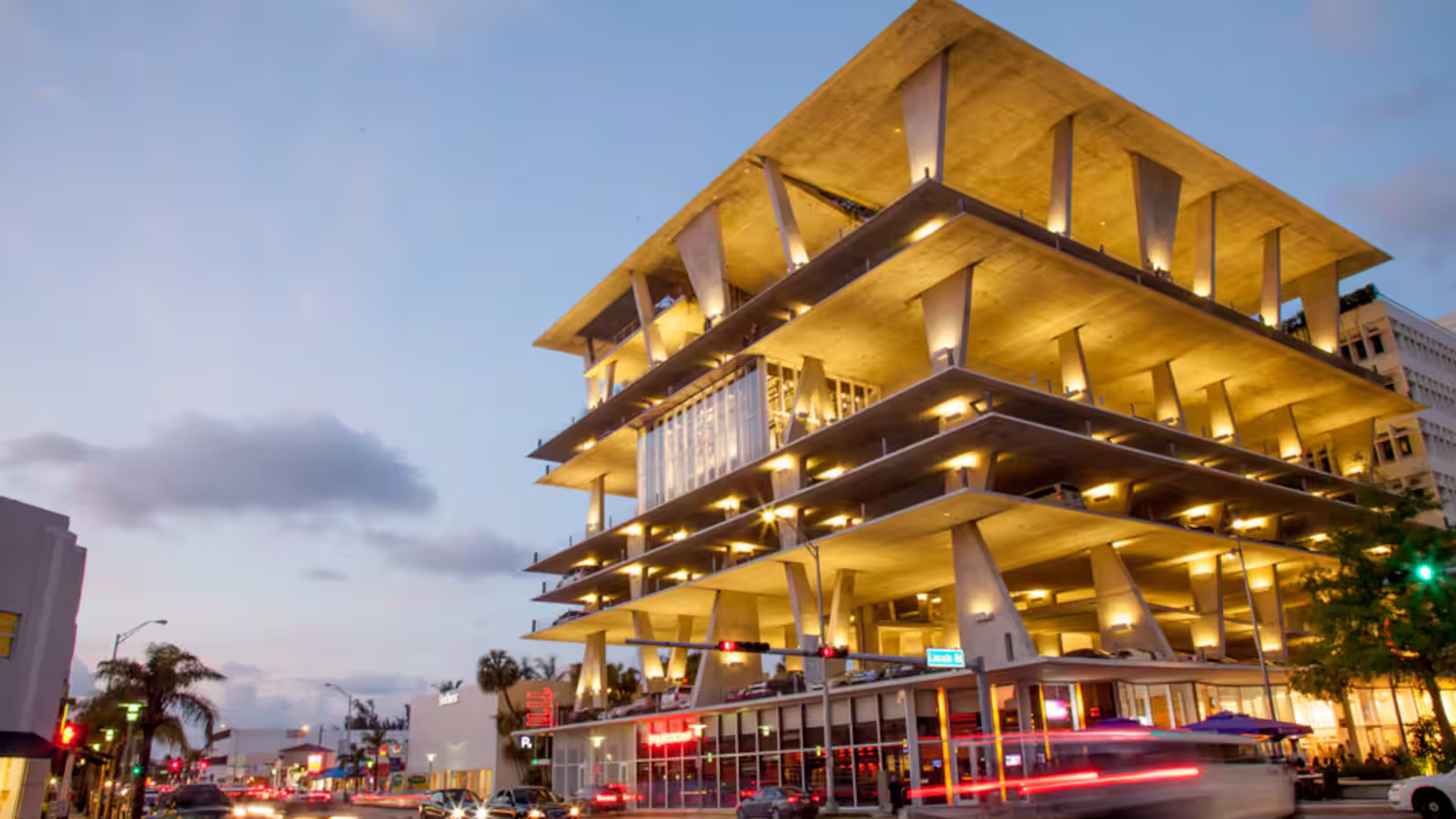 The illuminated exterior of 1111 Lincoln Road in Miami Beach at dusk.