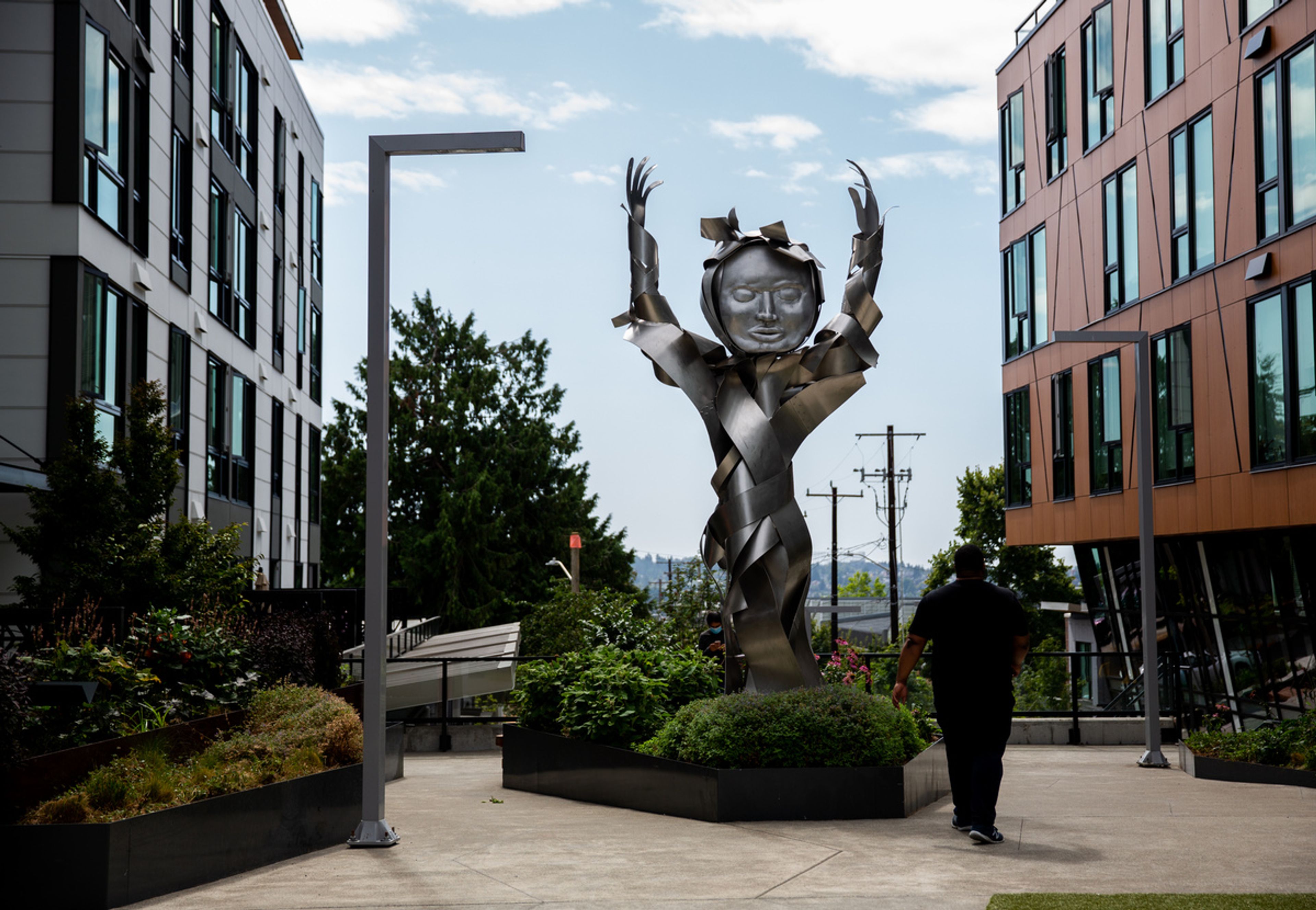 metal sculpture with hands up in the air