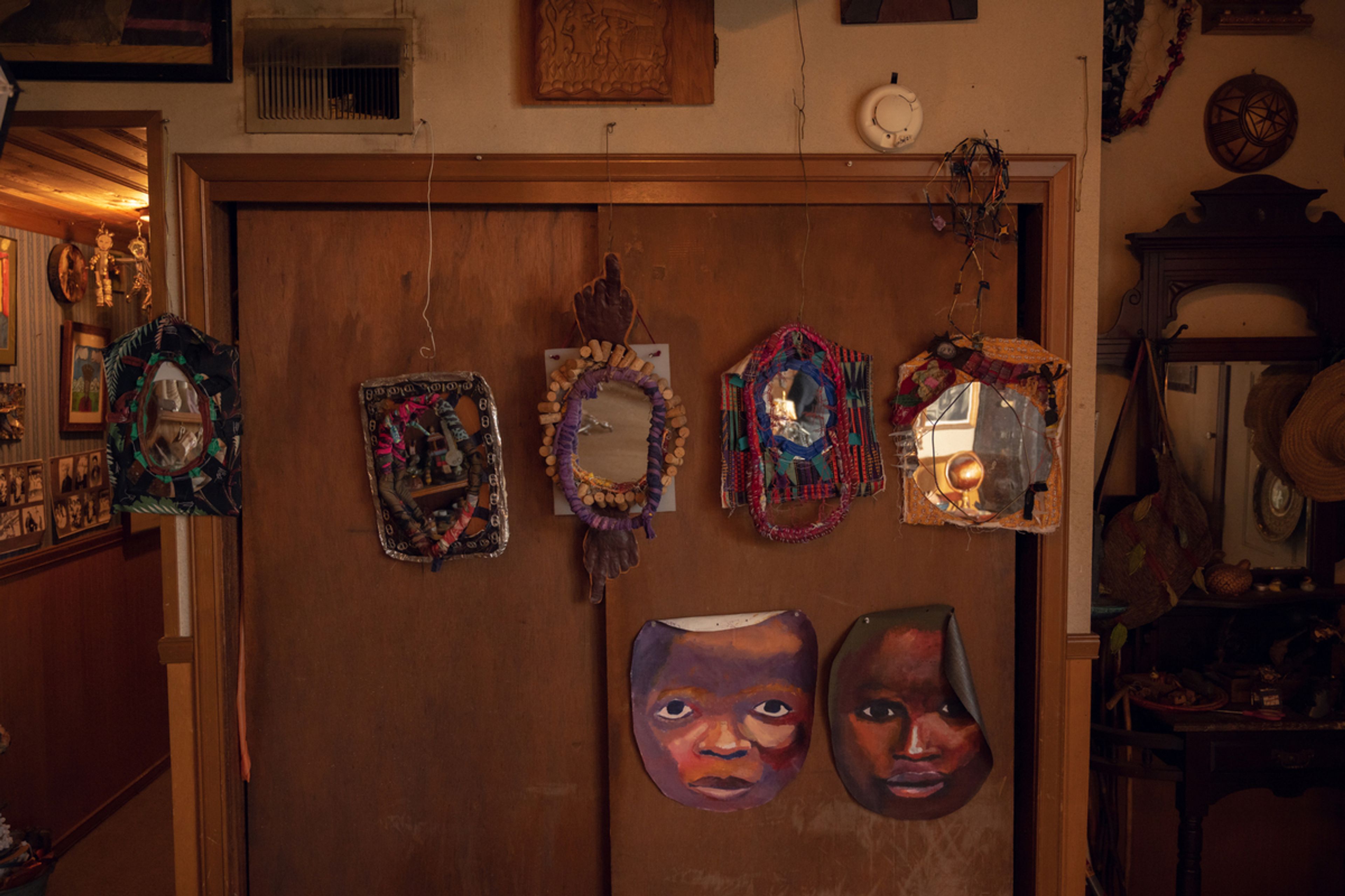 closet door with paper masks (depicting faces) and bracelets on top