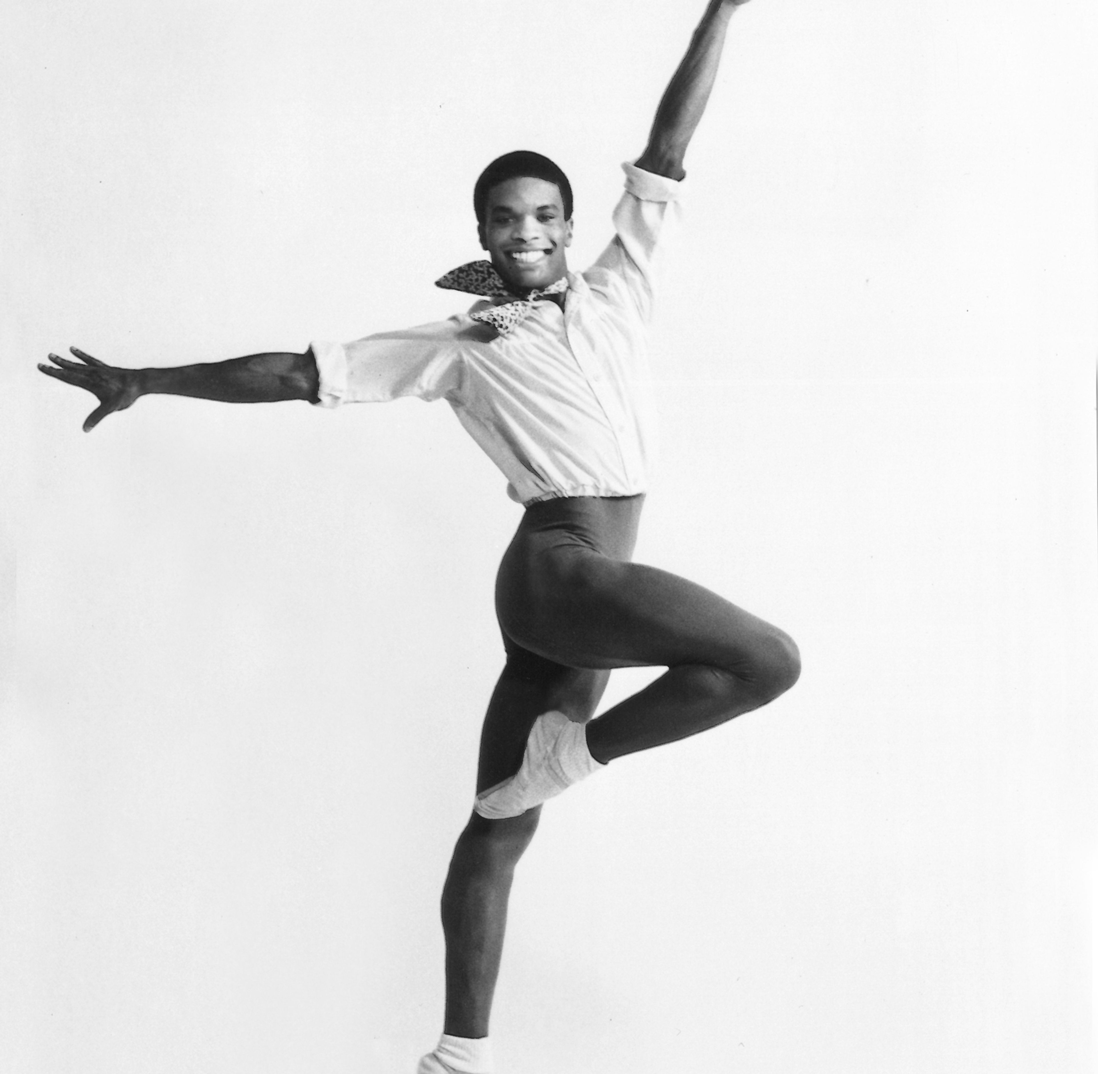 Person in tight dance leotards with hands up in the air in ballet pose