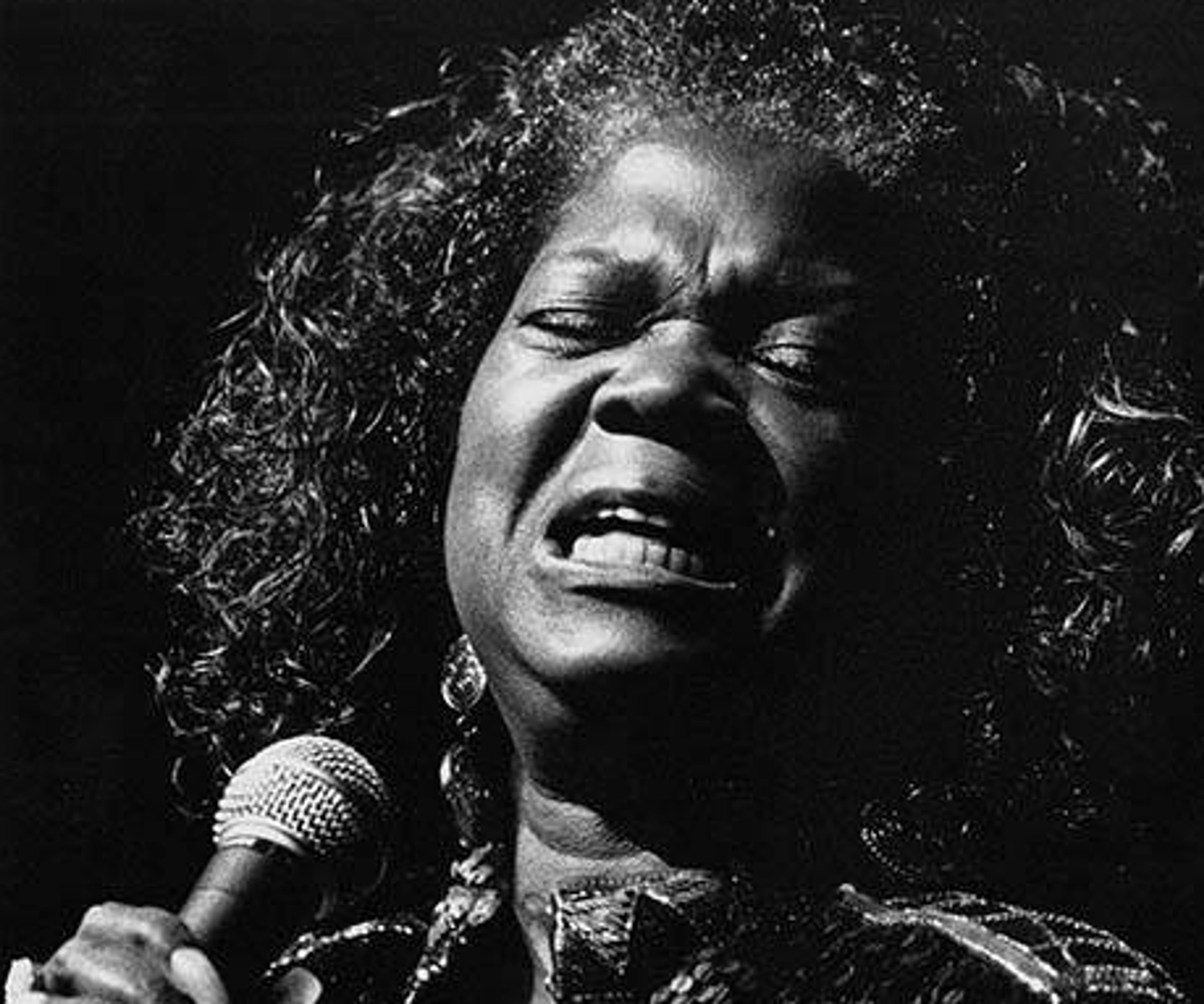black and white image of woman singing into a microphone