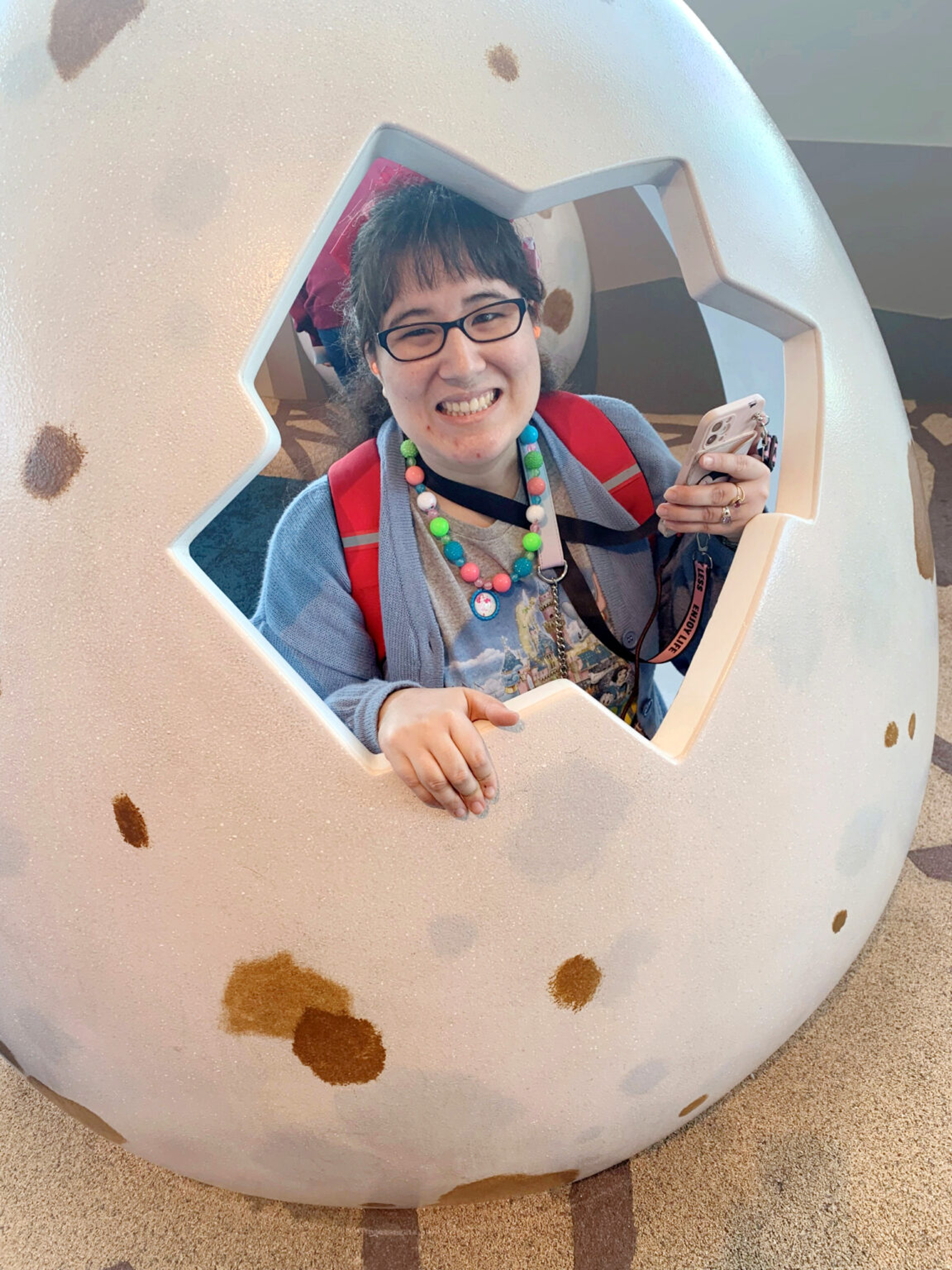 Girl stands in dinosaur egg