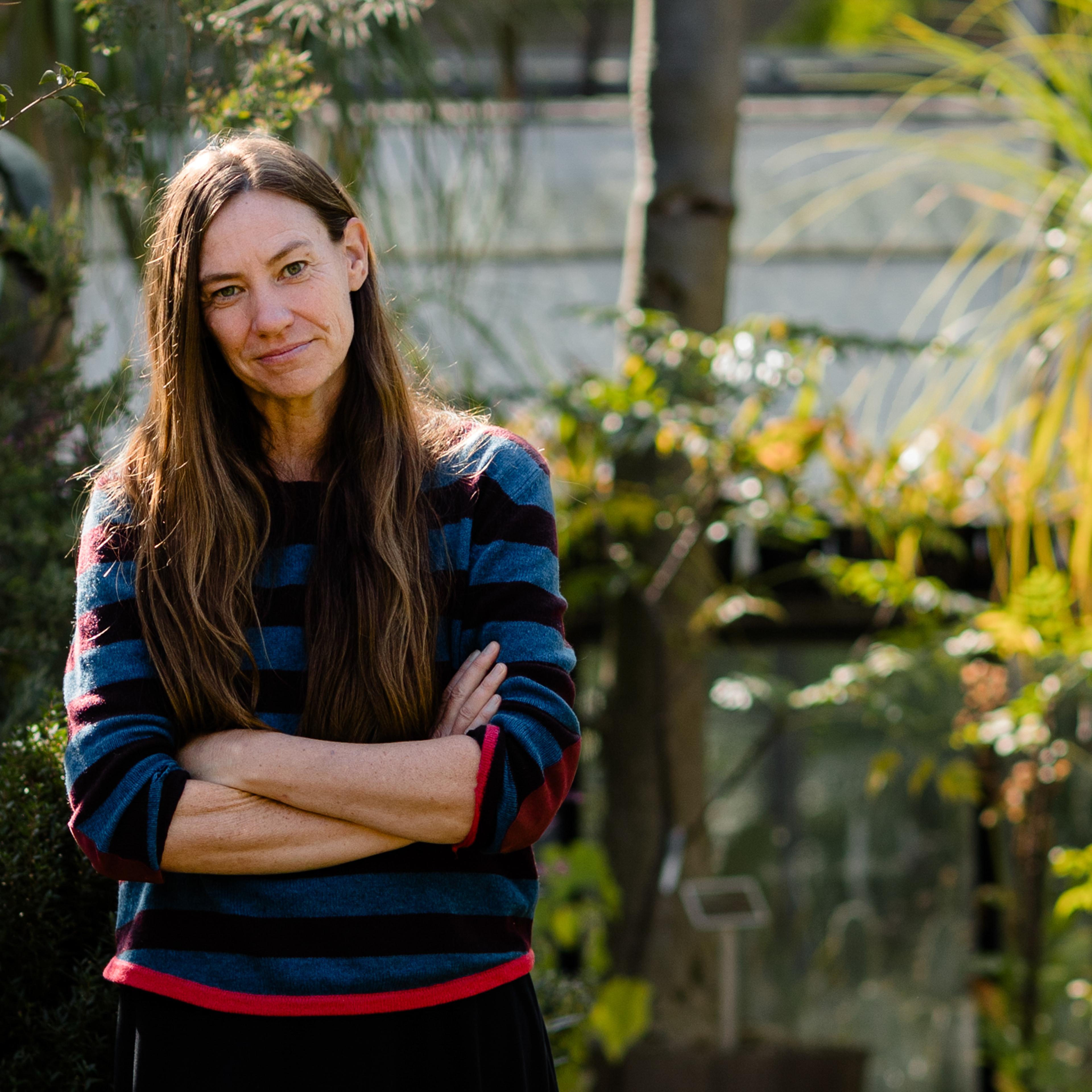 scientist stands among flora.