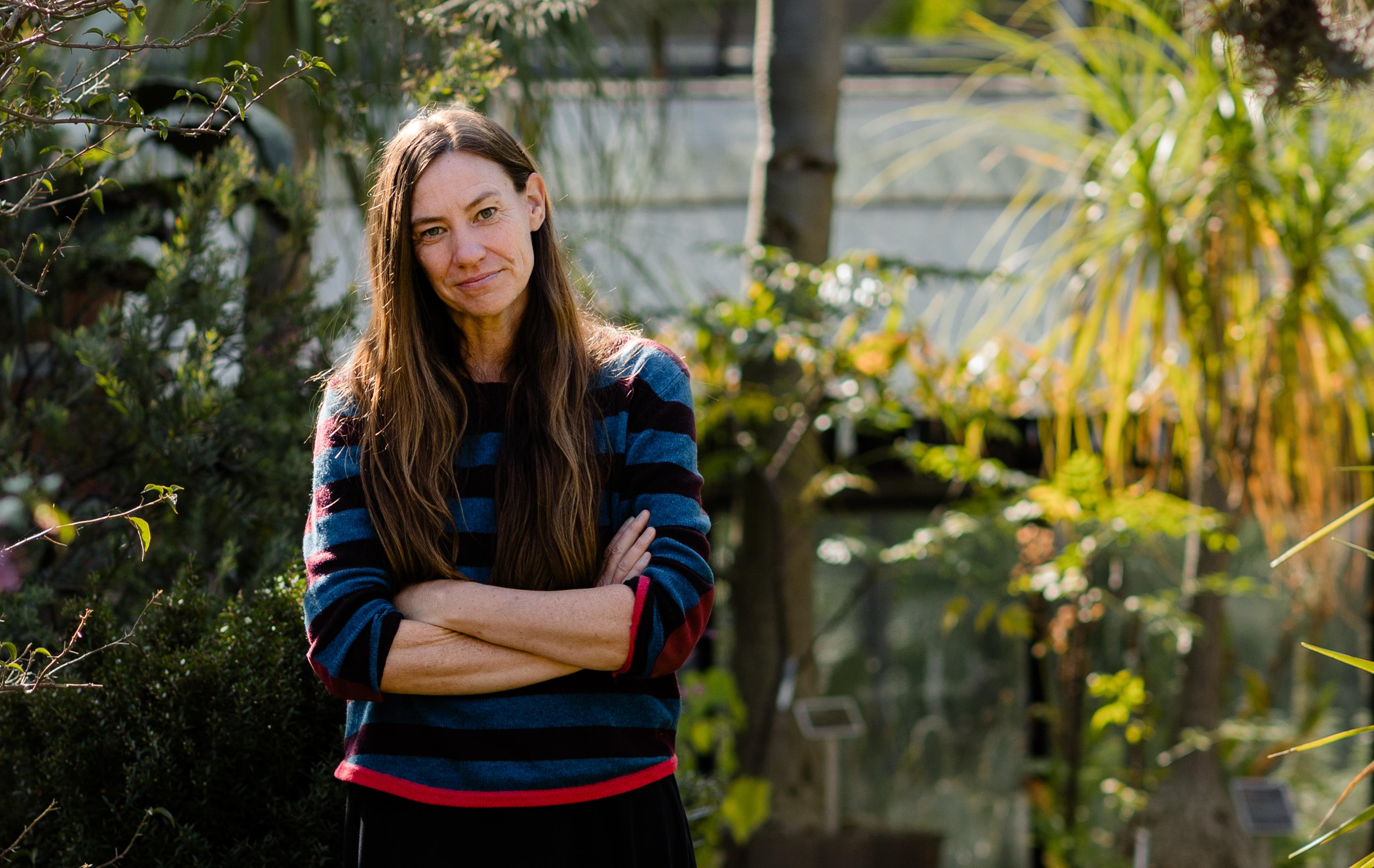 scientist stands among flora.