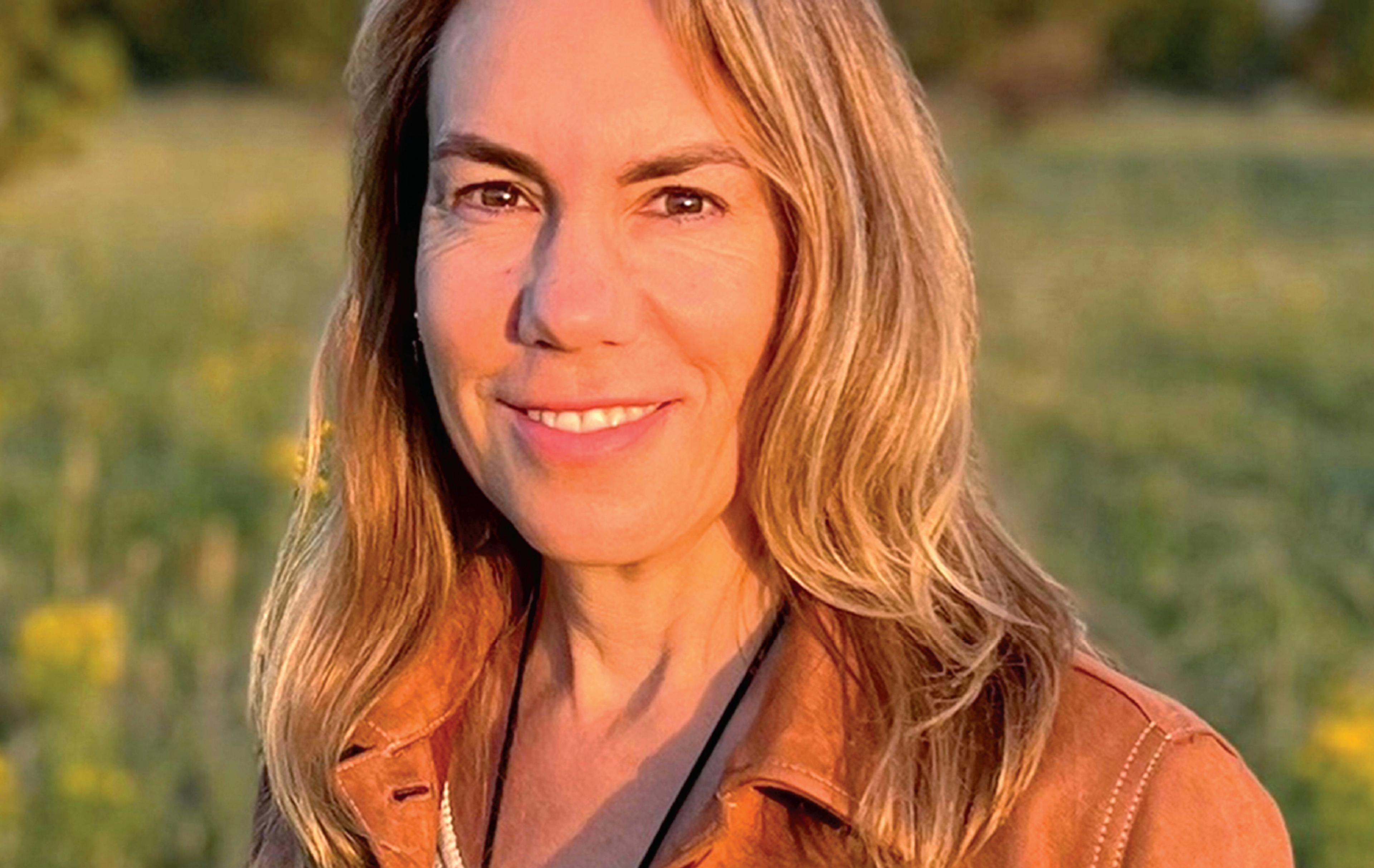 woman smiling with a brown jacket