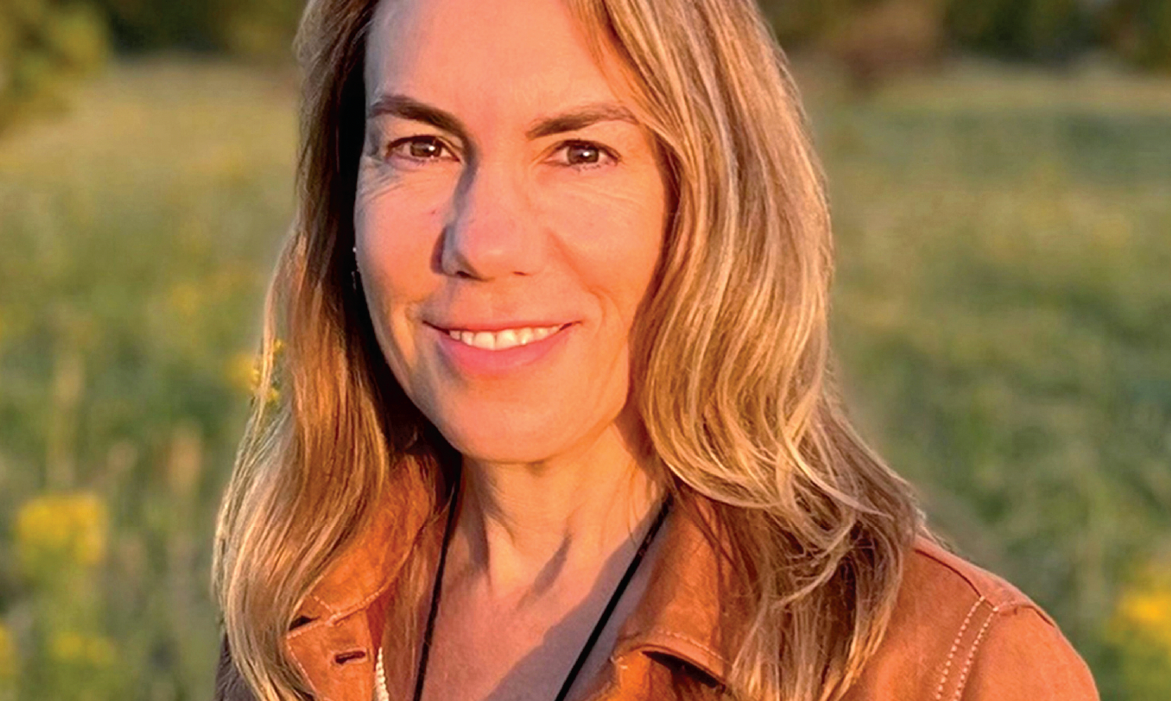 woman smiling with a brown jacket