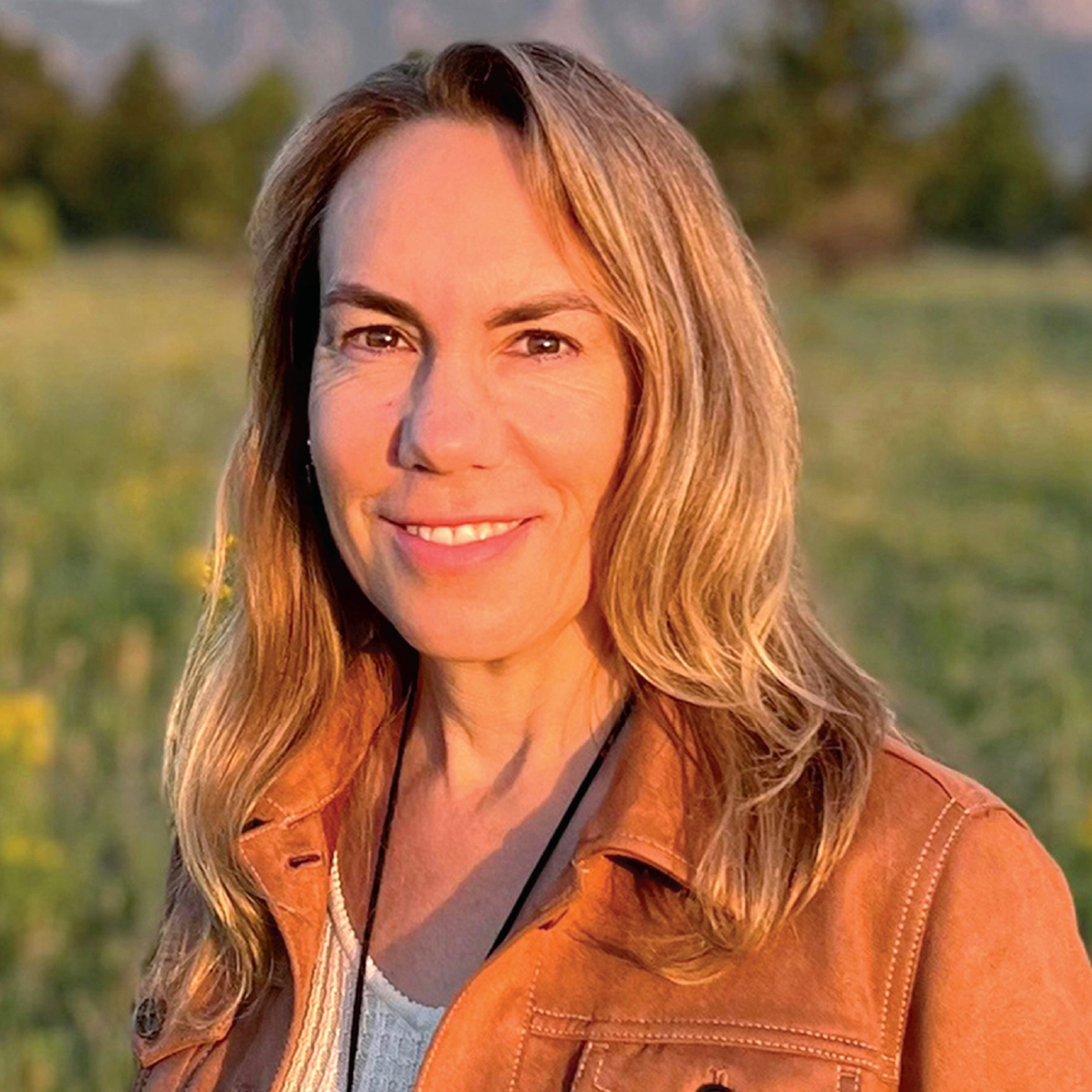 woman smiling with a brown jacket