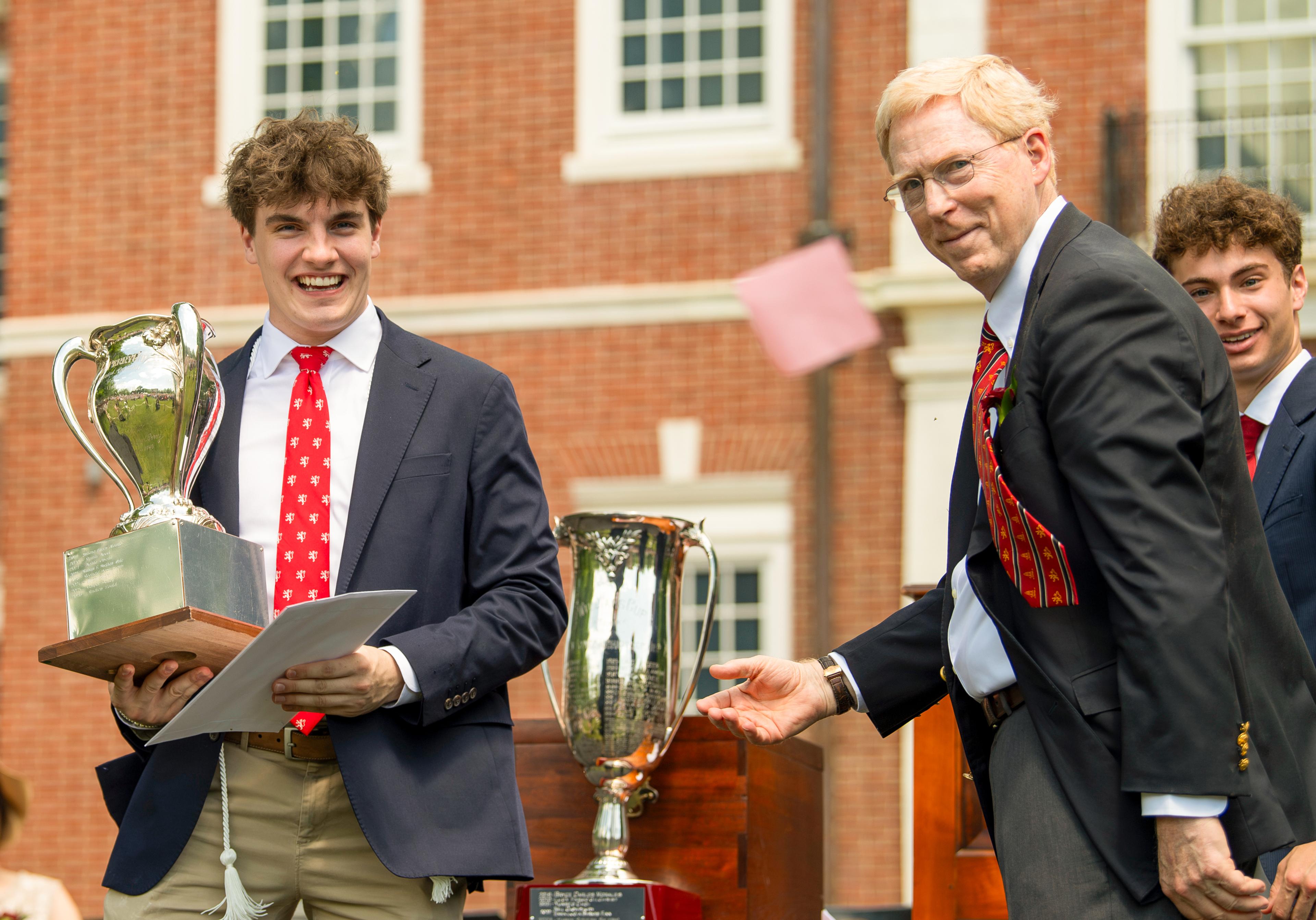 student receiving a prize cup on graduation day