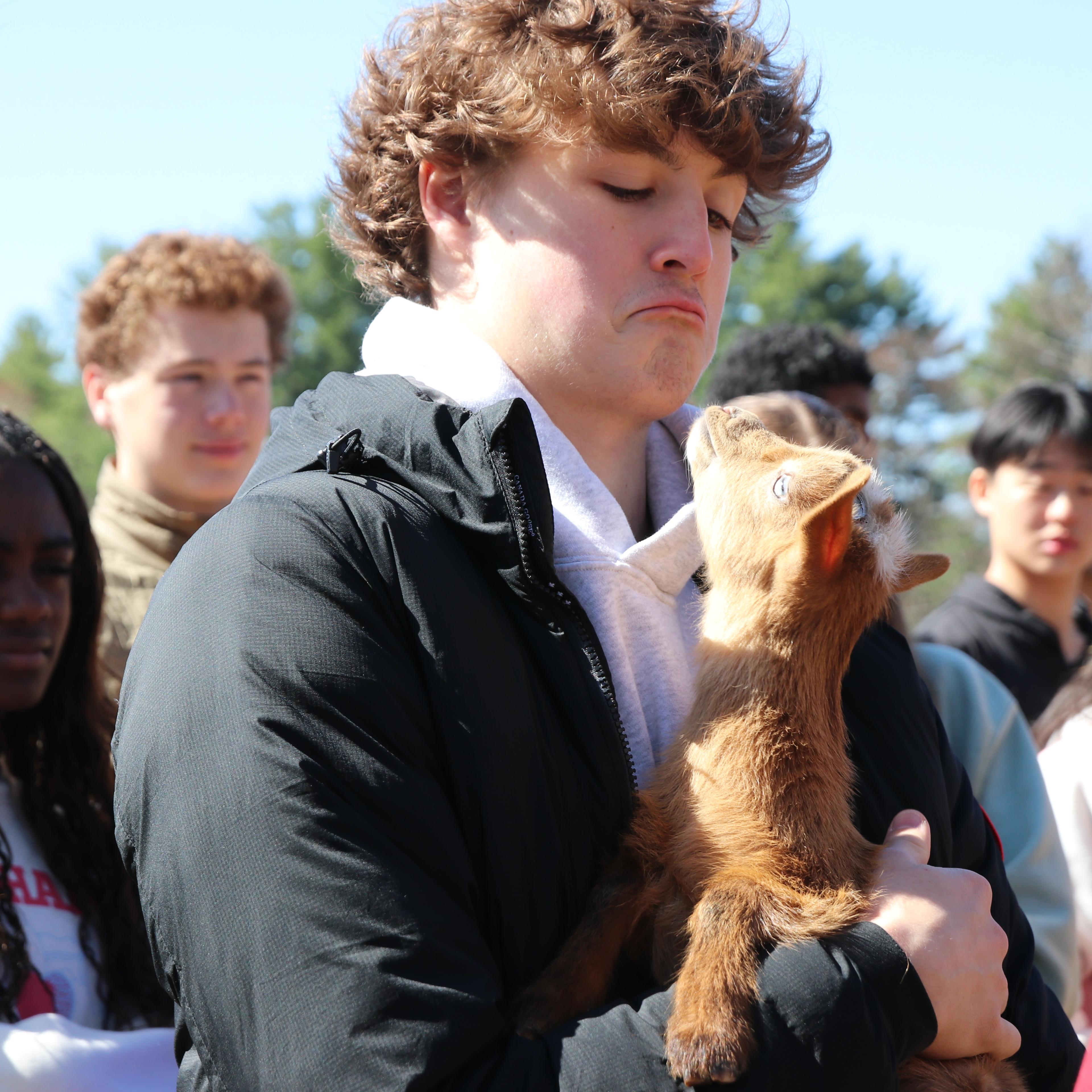Student holds baby goat