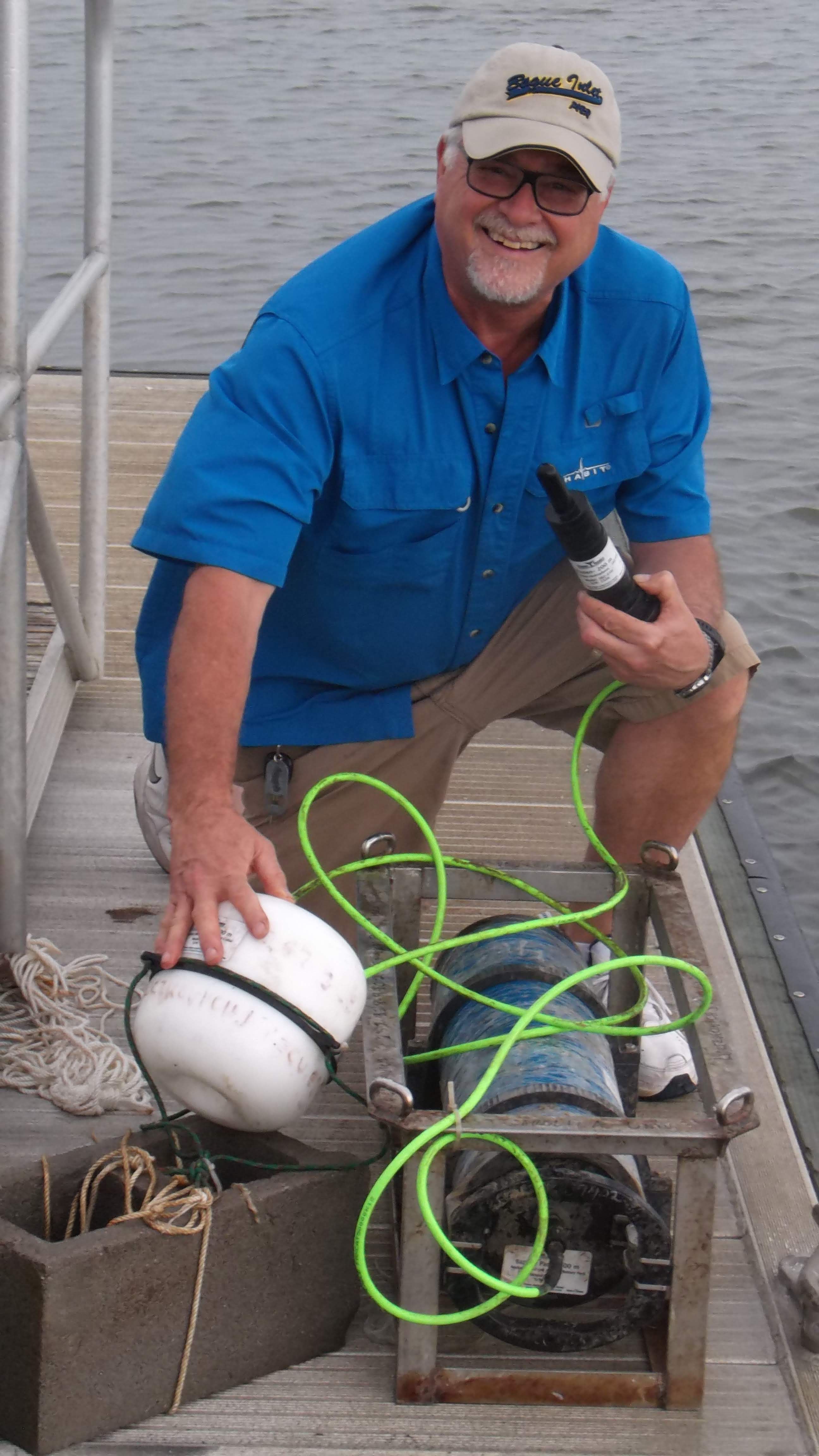 Man stands with marine biology equipment on a dock