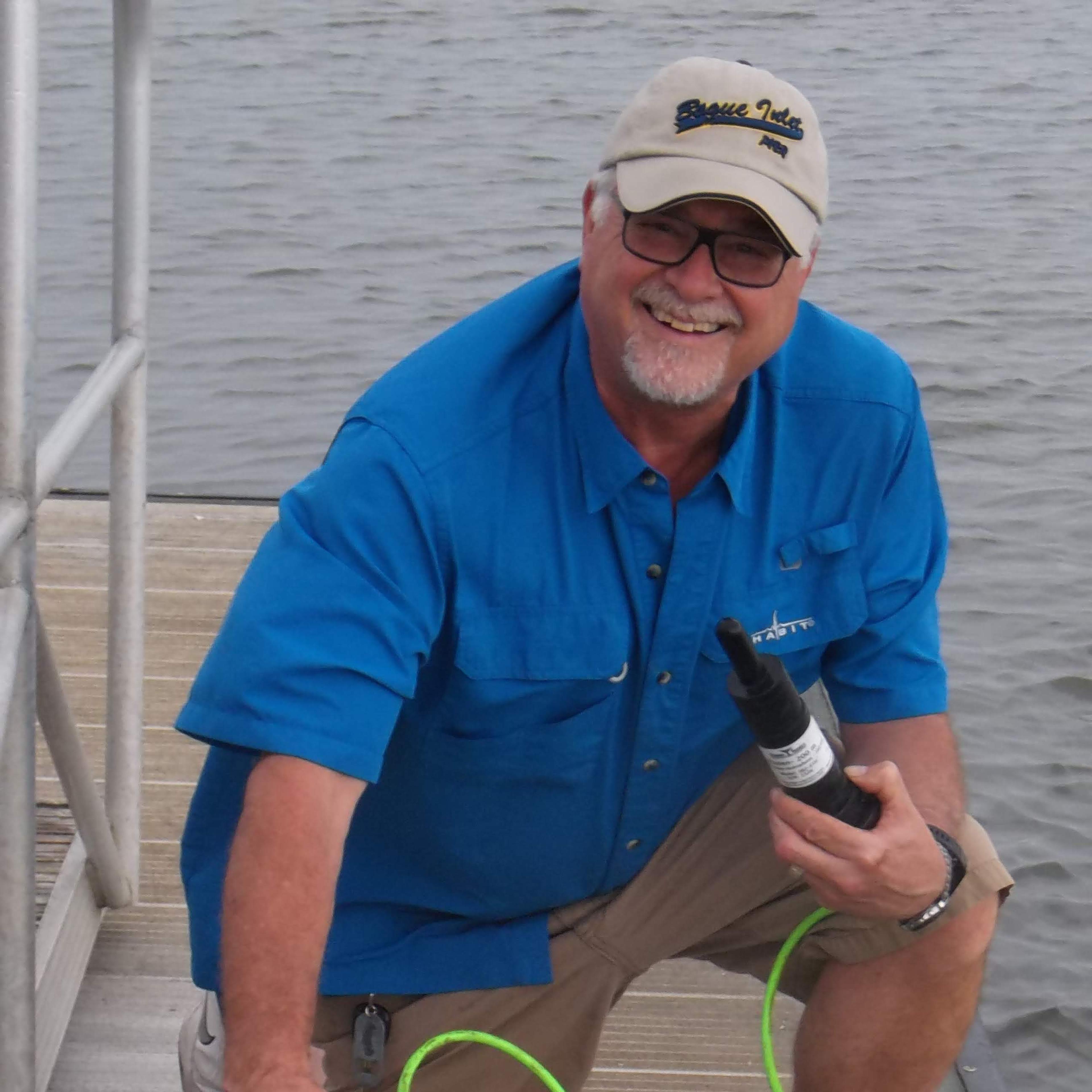 Man stands with marine biology equipment on a dock