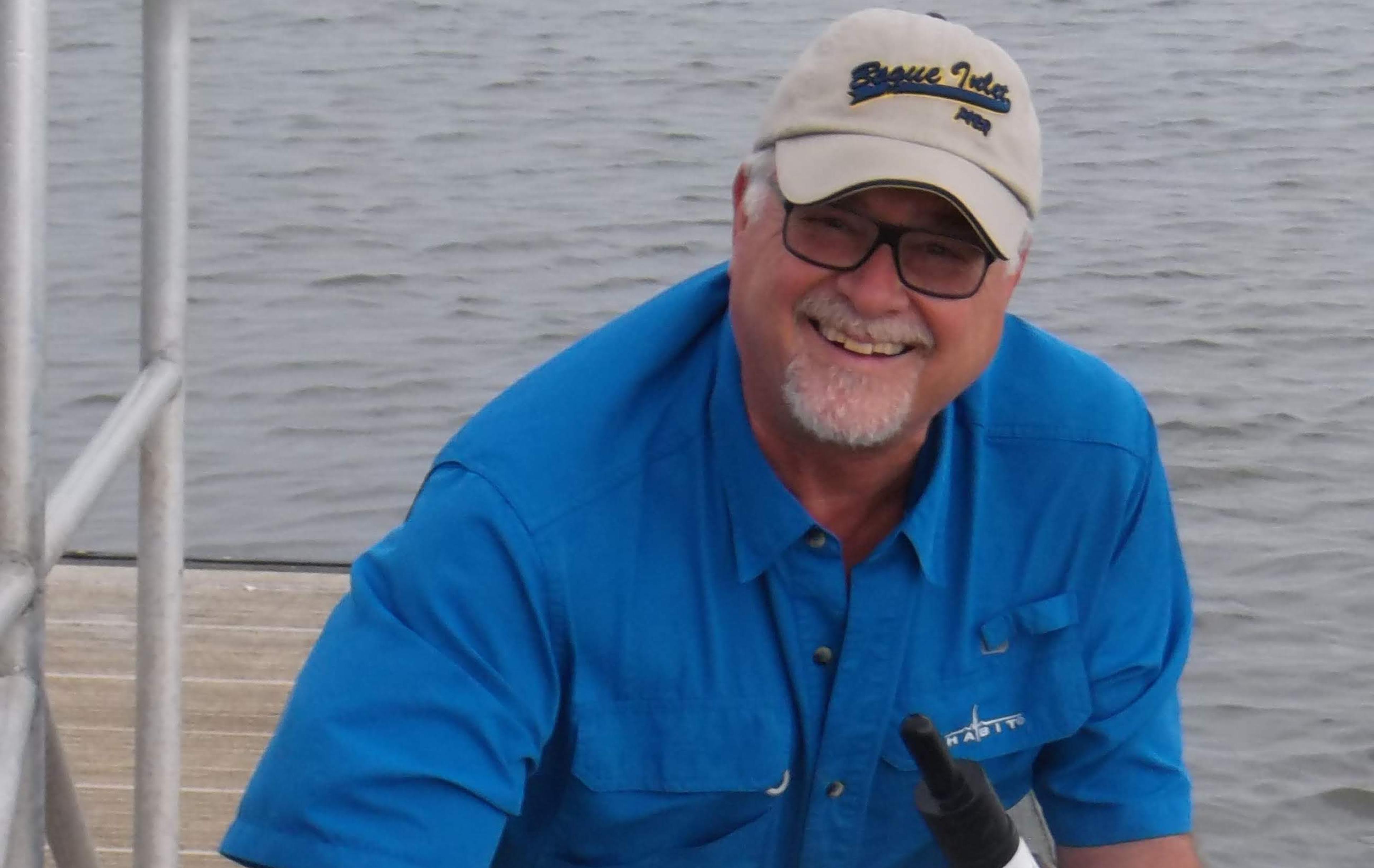 Man stands with marine biology equipment on a dock