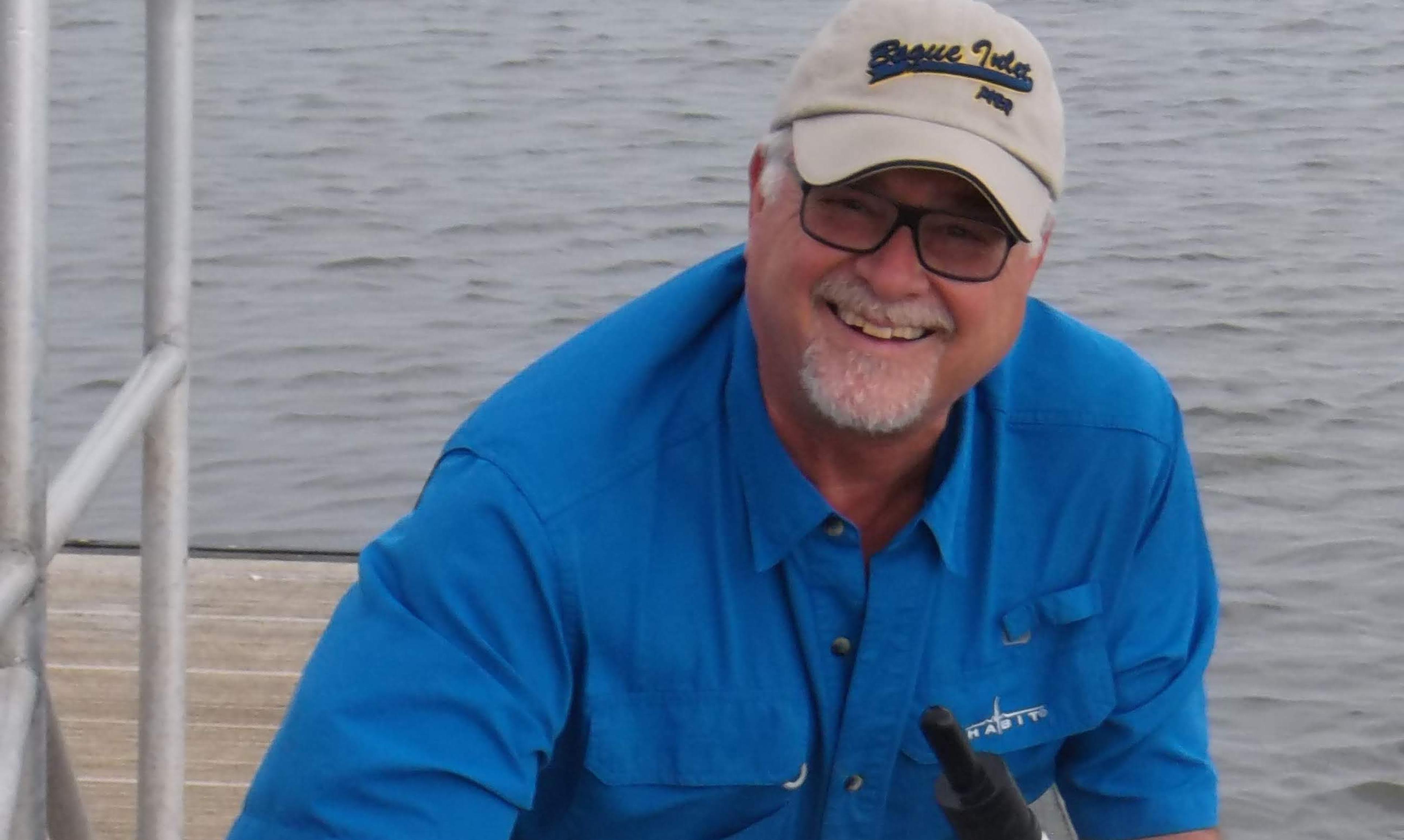 Man stands with marine biology equipment on a dock