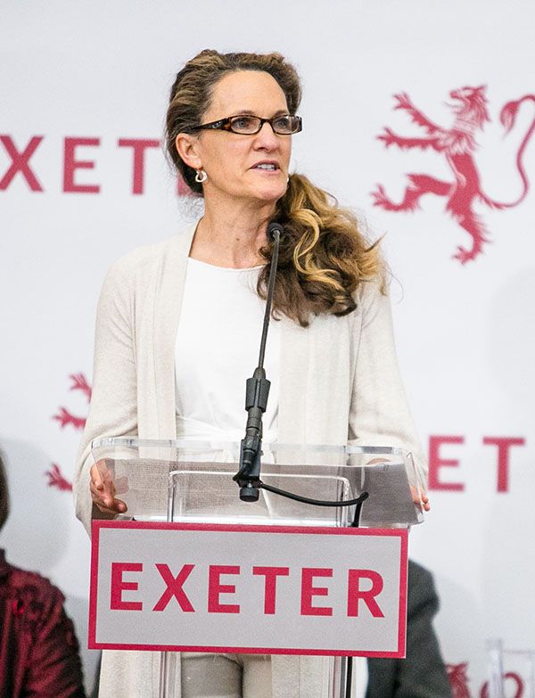 Hilary Hall stands at a podium and speaks to a crowd.
