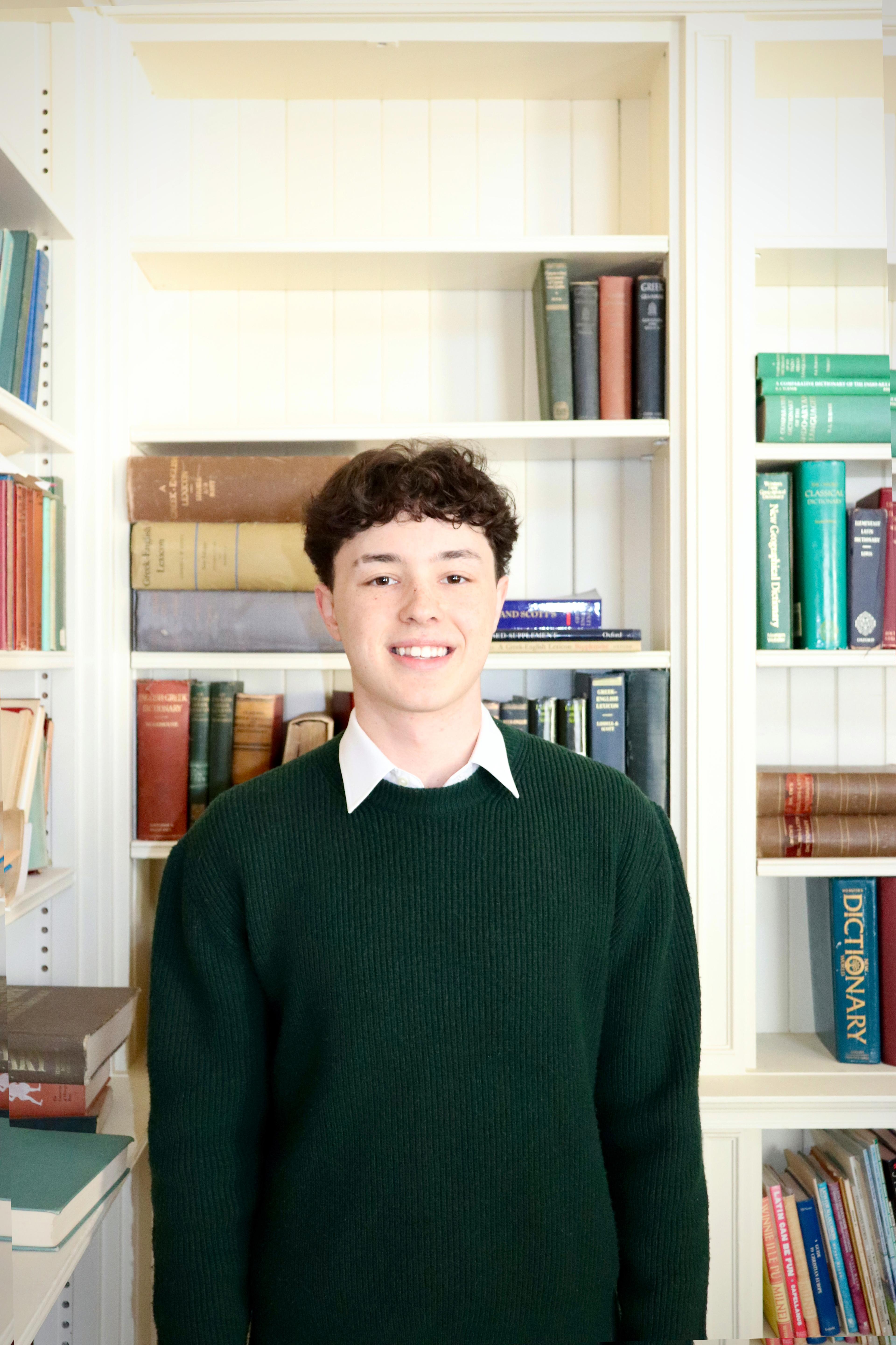 Student stands in front of books in the Davis Library