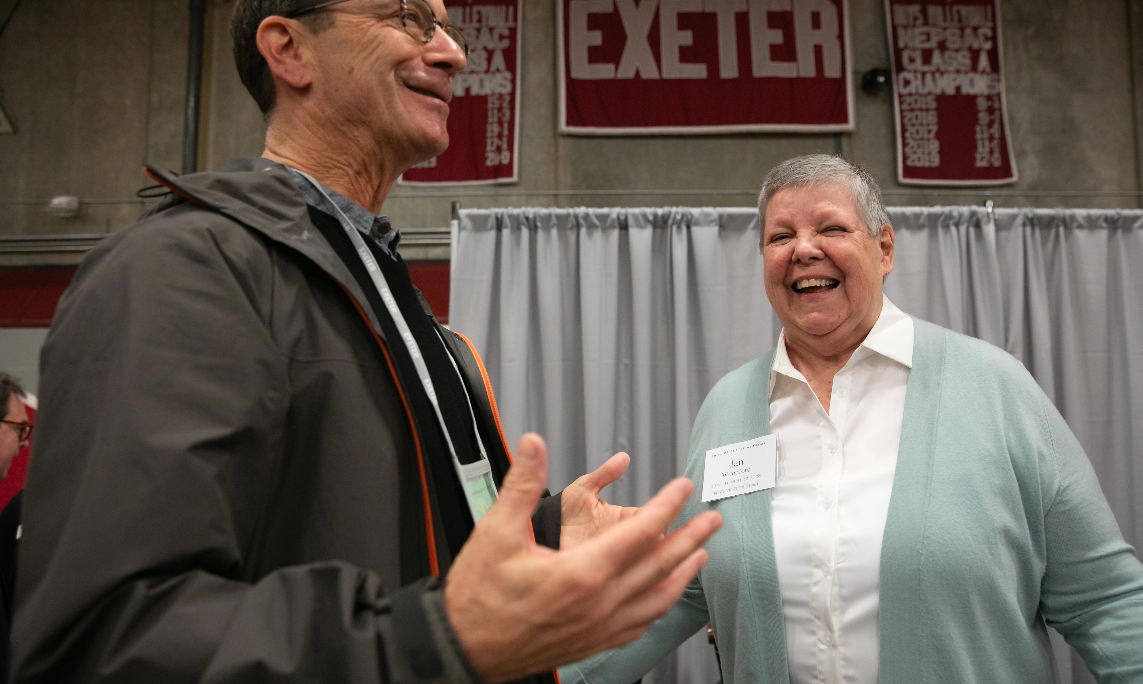 Woman stands on stage laughing