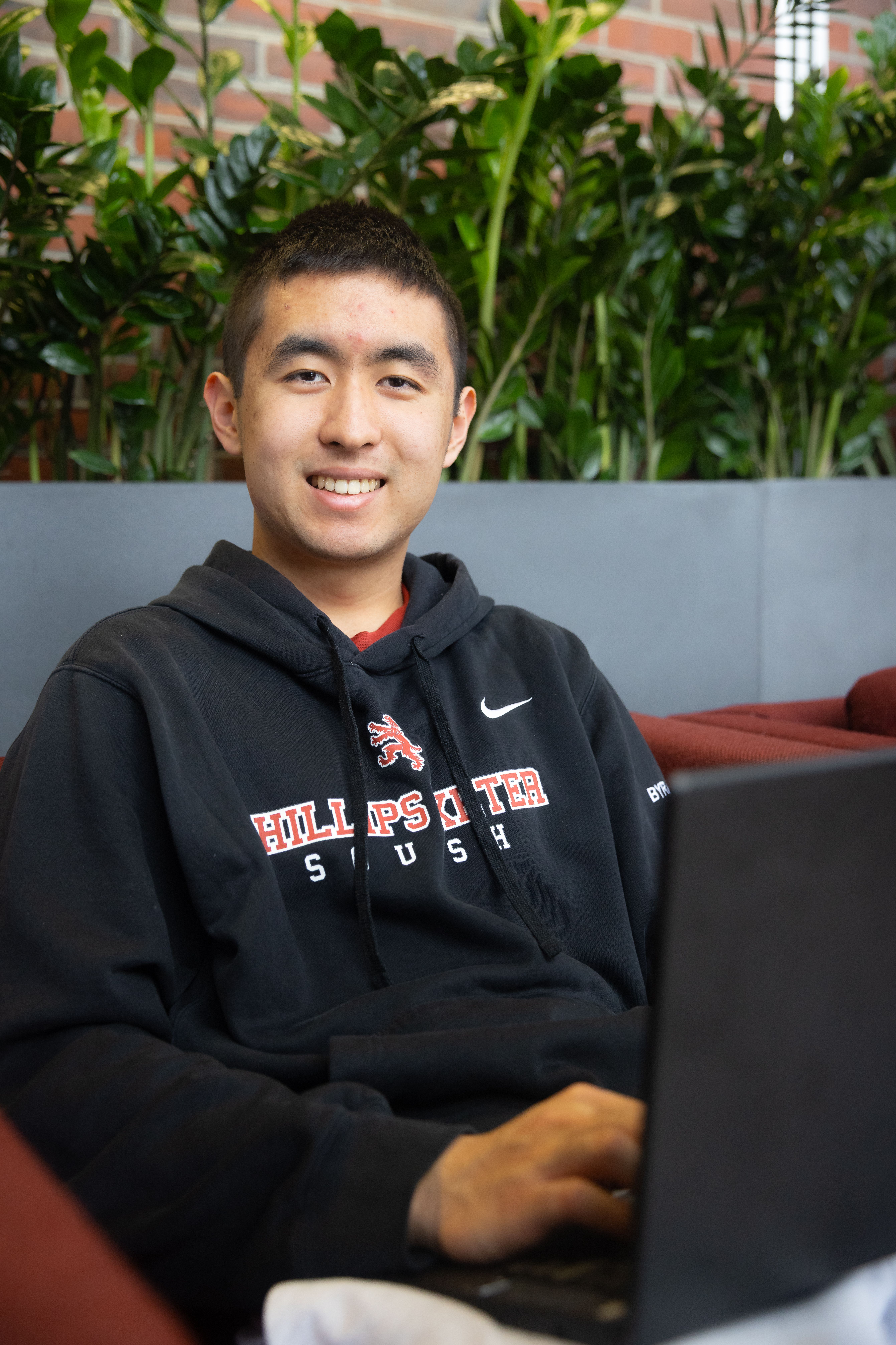 Student sits with laptop on a couch 