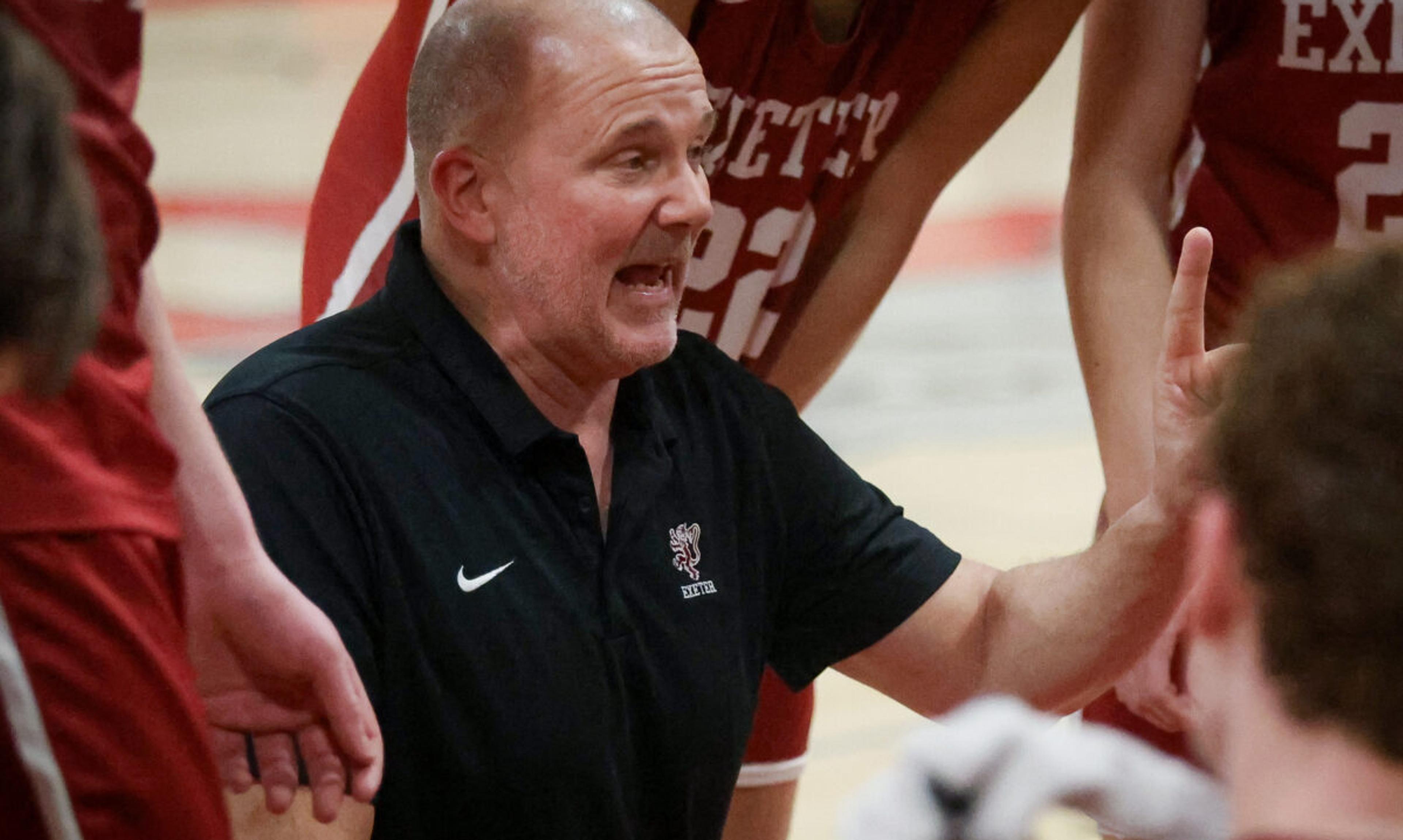 Coach kneels while giving a talk to players