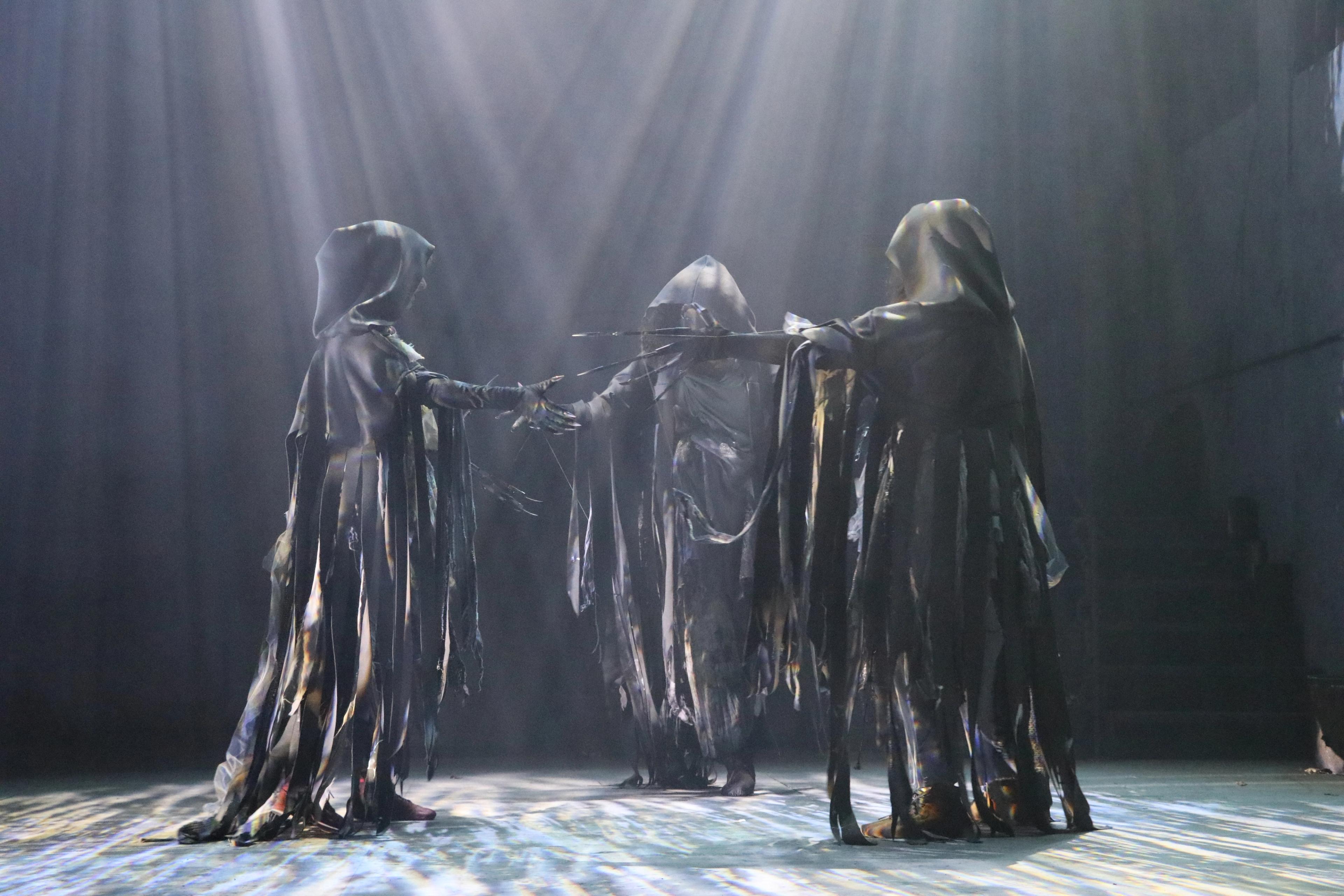 dark figures in Macbeth stage play