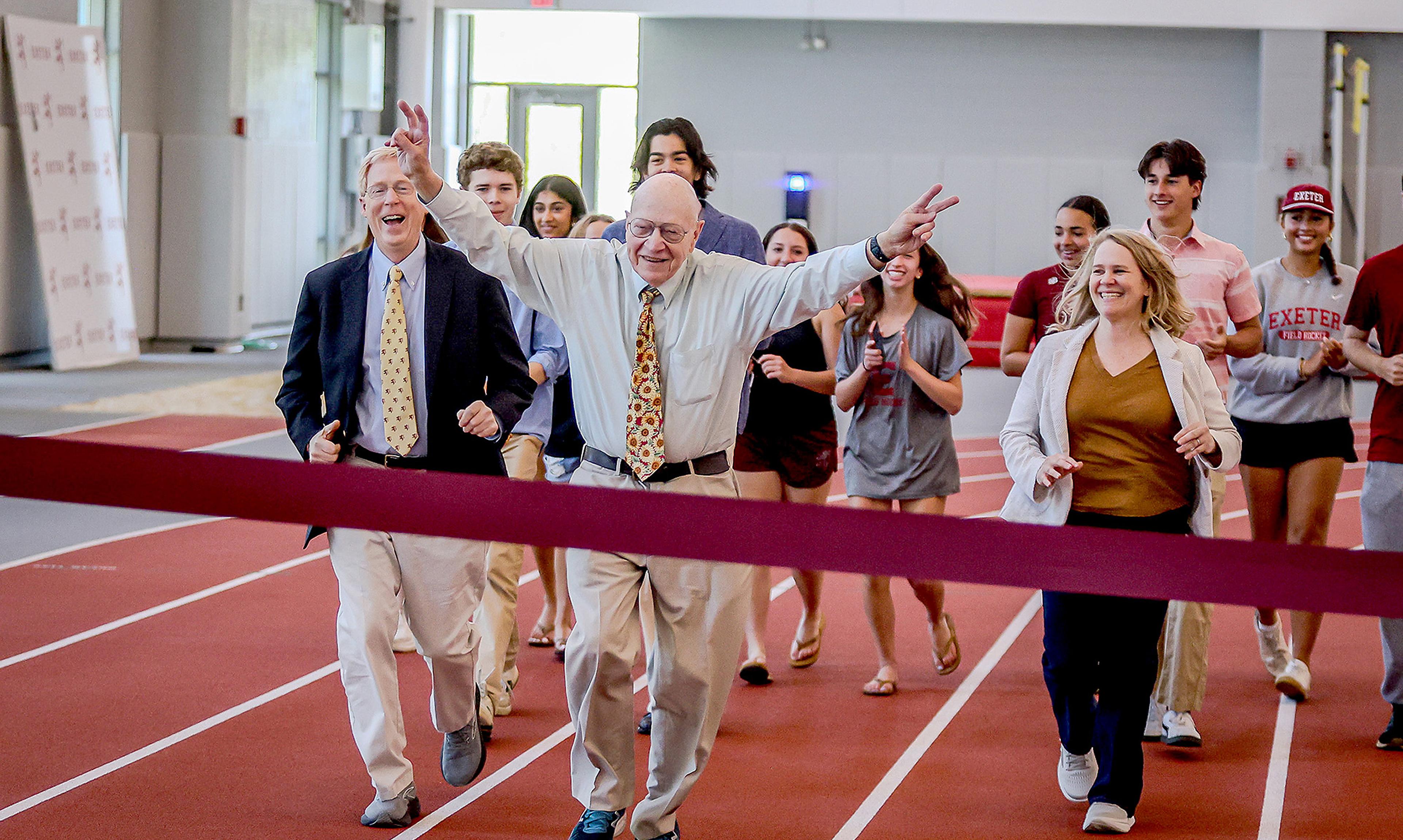 Group running across a finish line at Thompson Field House