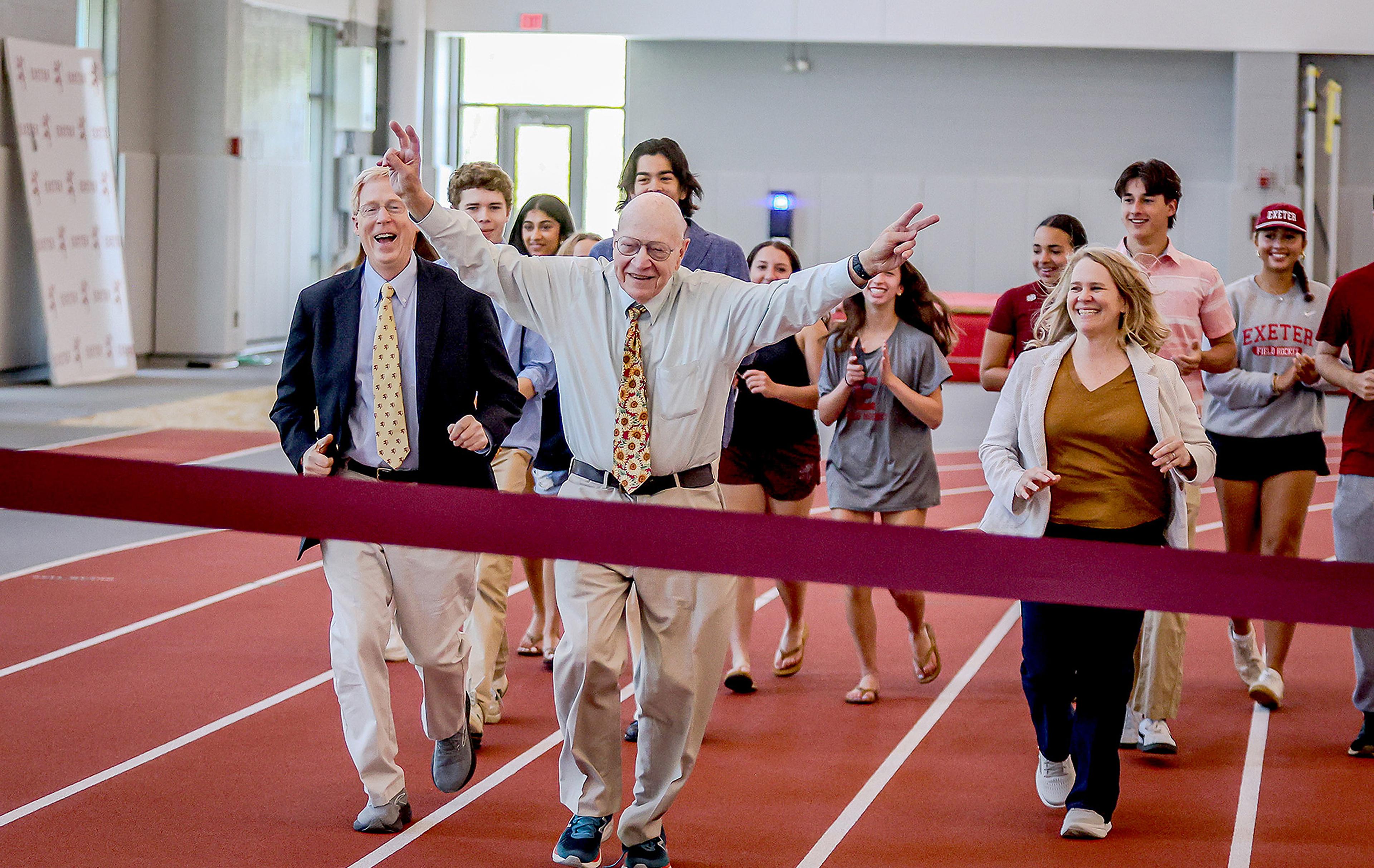Group running across a finish line at Thompson Field House