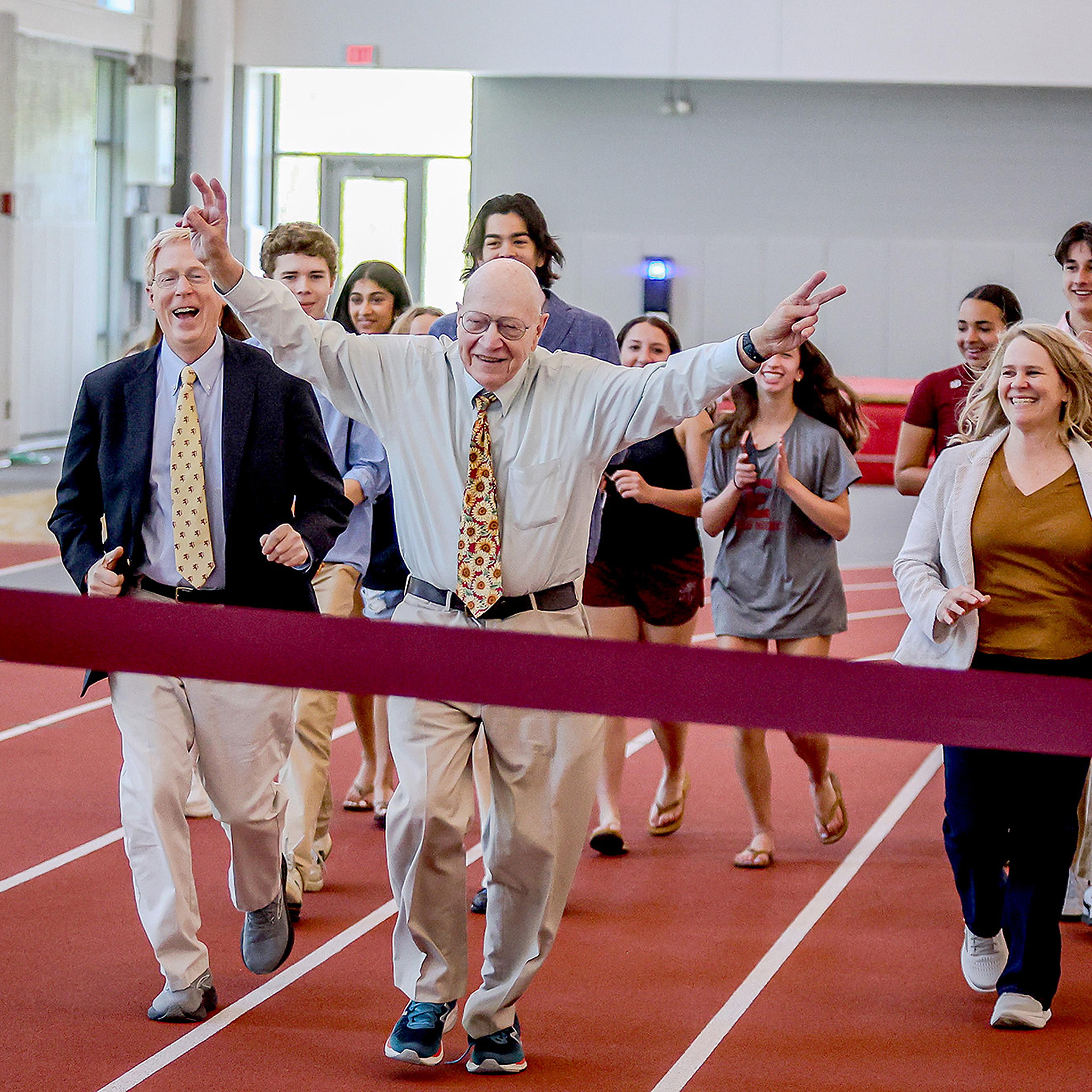 Group running across a finish line at Thompson Field House