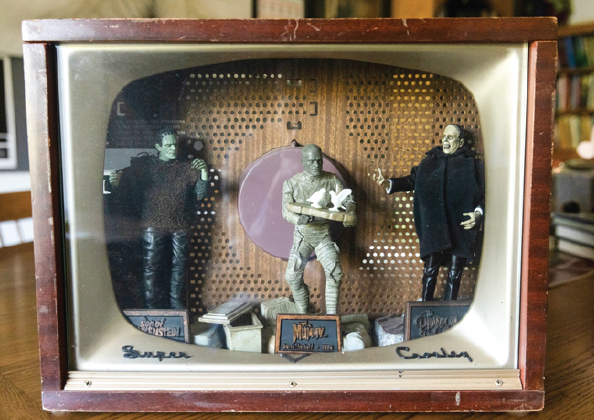 Wooden TV frame with figures in it.