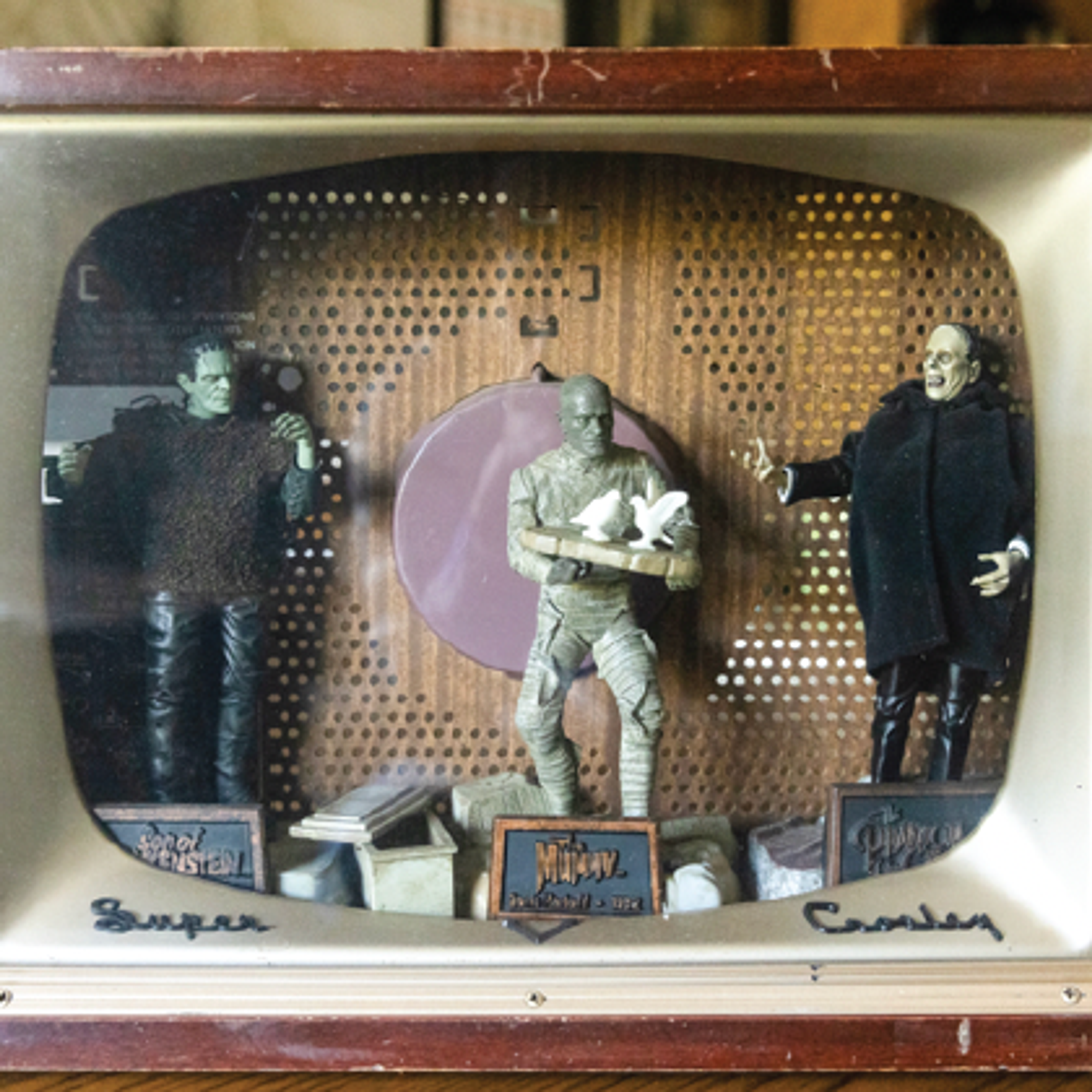 Wooden TV frame with figures in it.