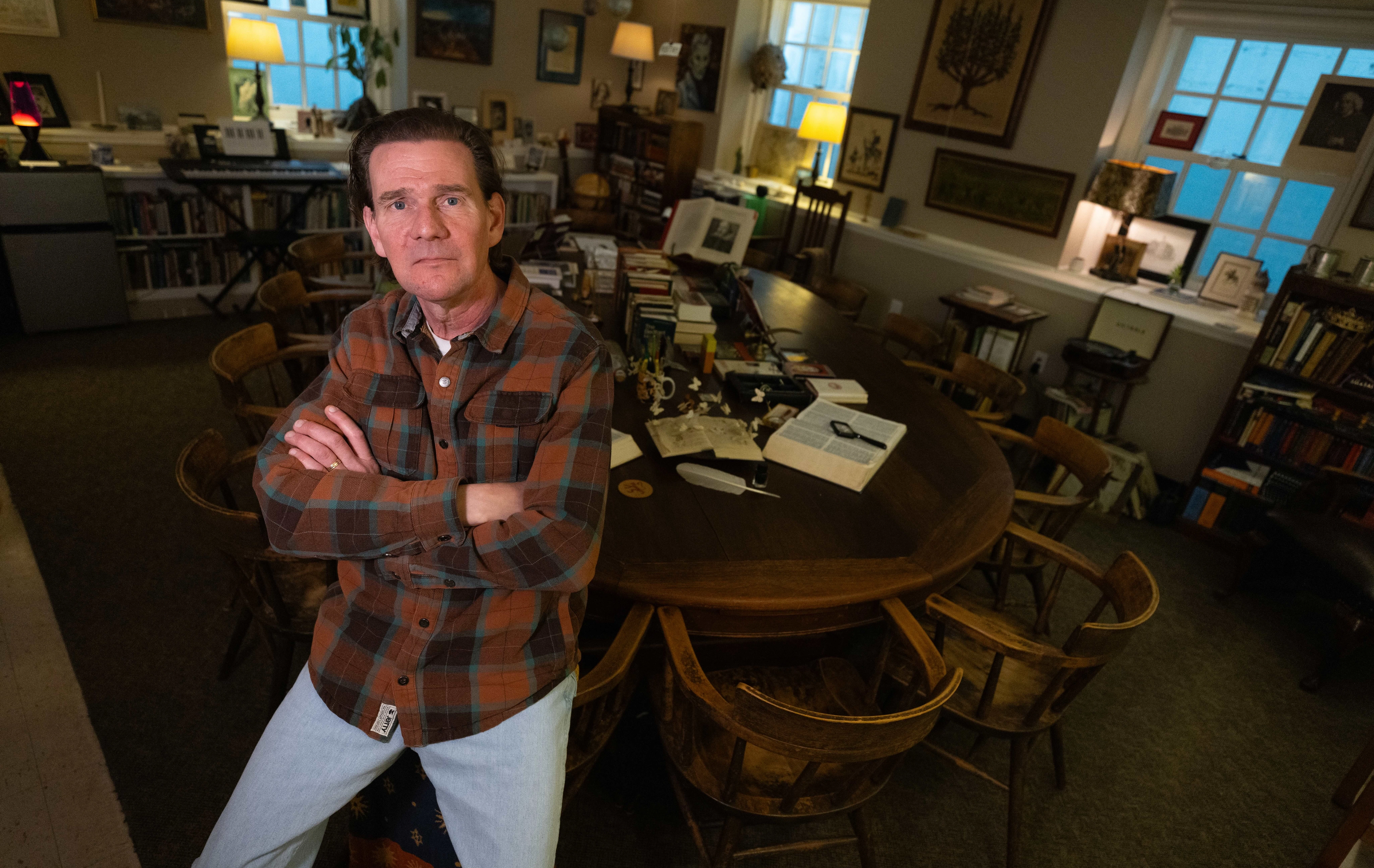 Teacher sits on edge of a harkness table