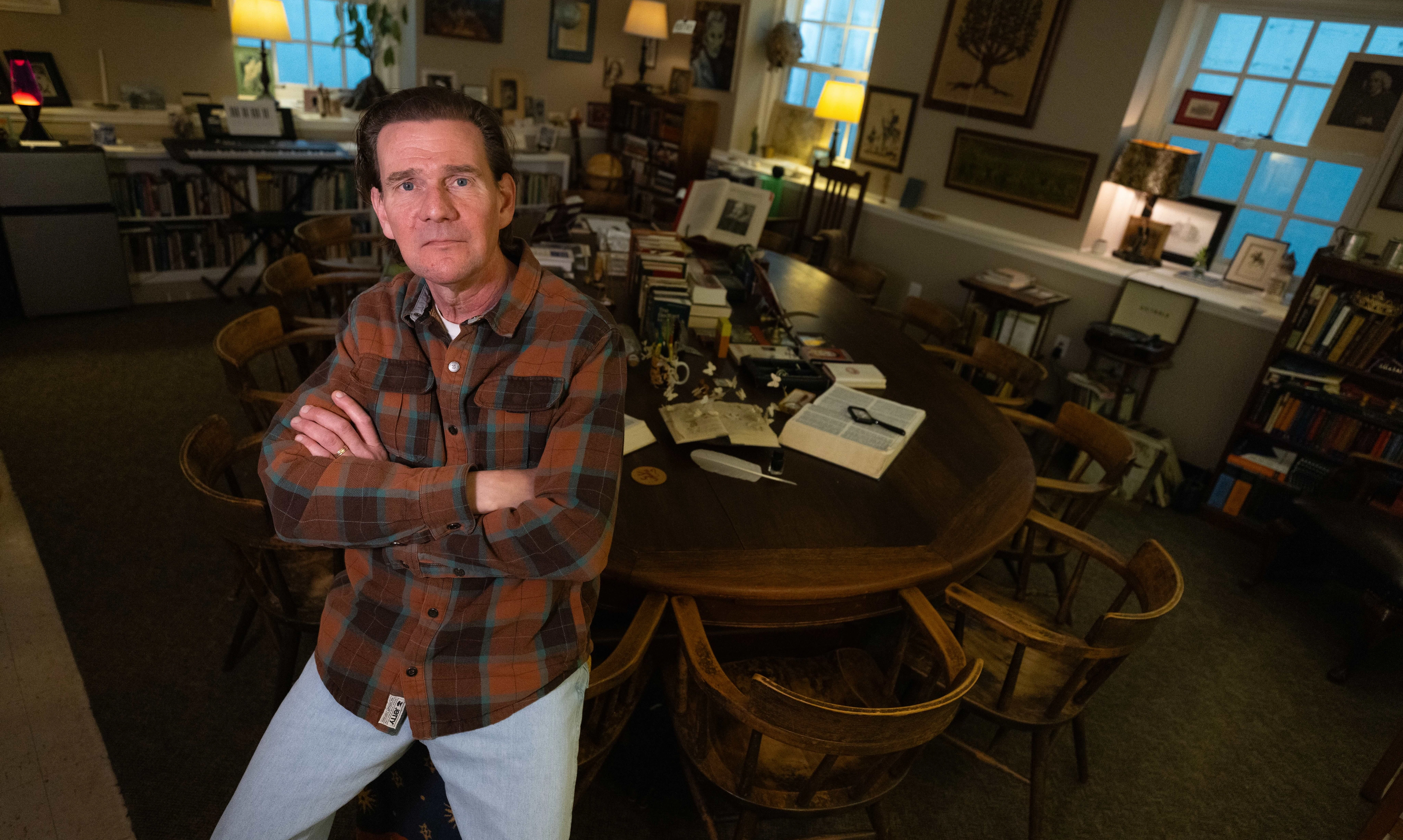 Teacher sits on edge of a harkness table