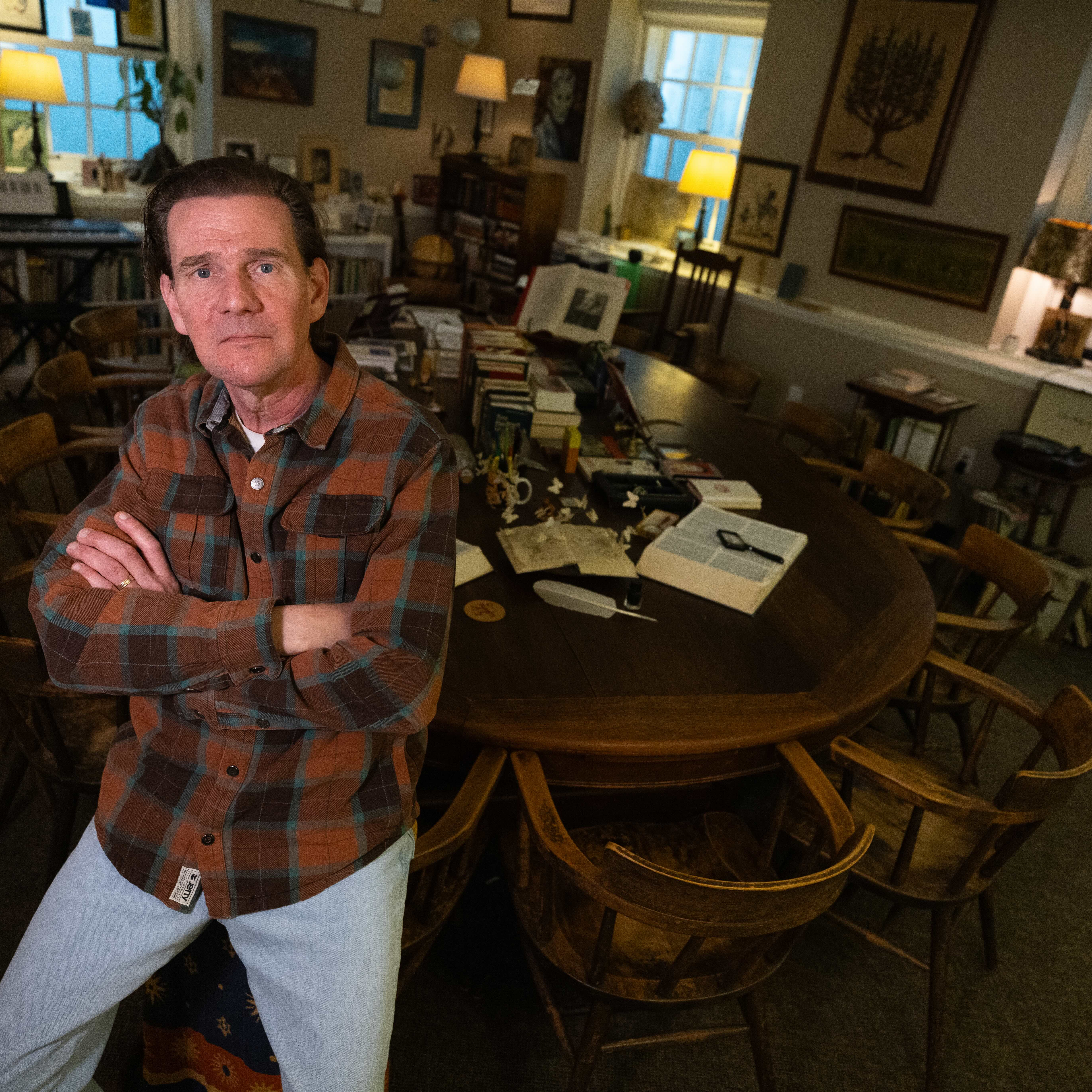 Teacher sits on edge of a harkness table